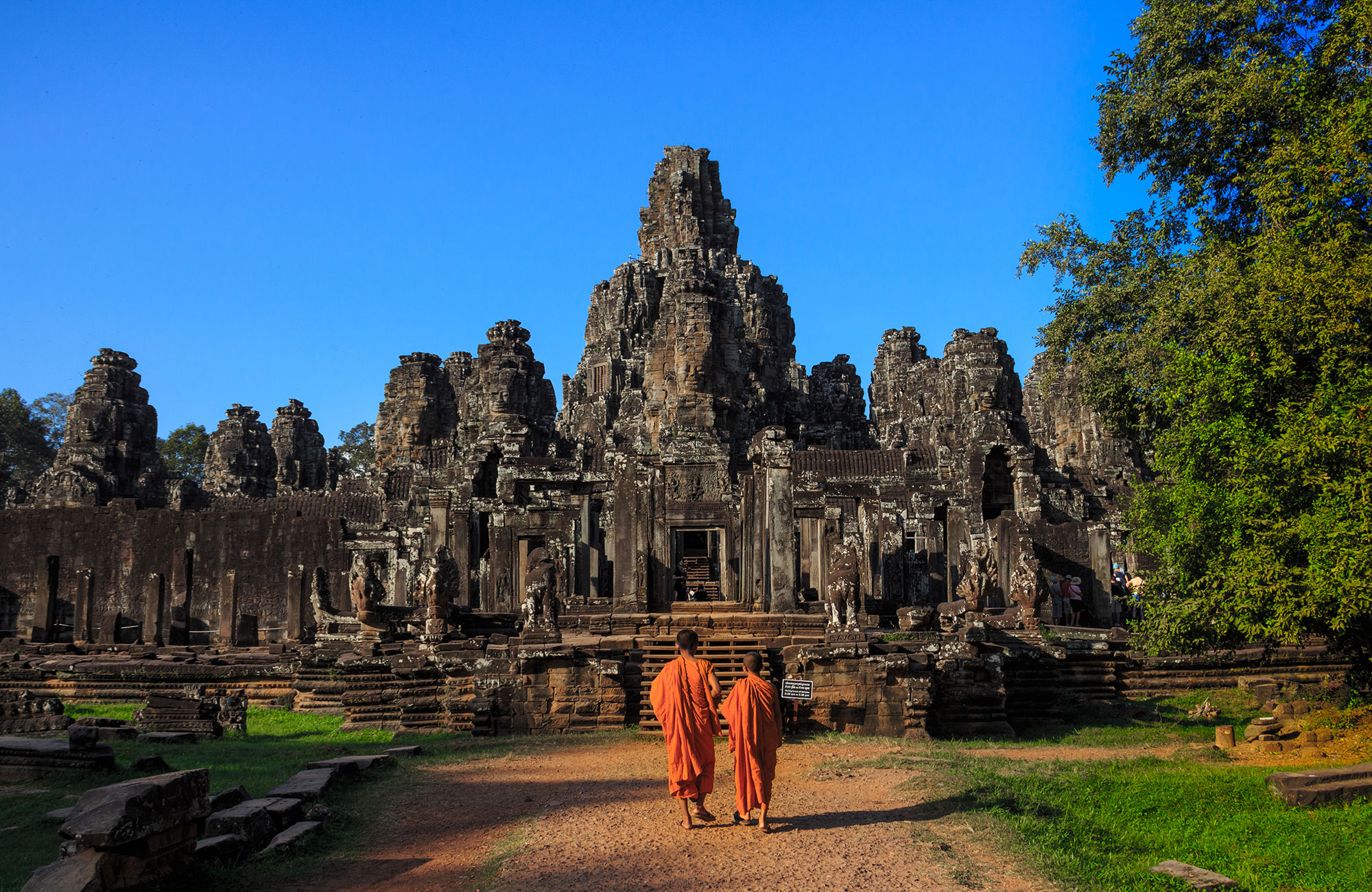Image of two young monks walking towards a temple ruin in Angkor Wat, Cambodia - KILROY