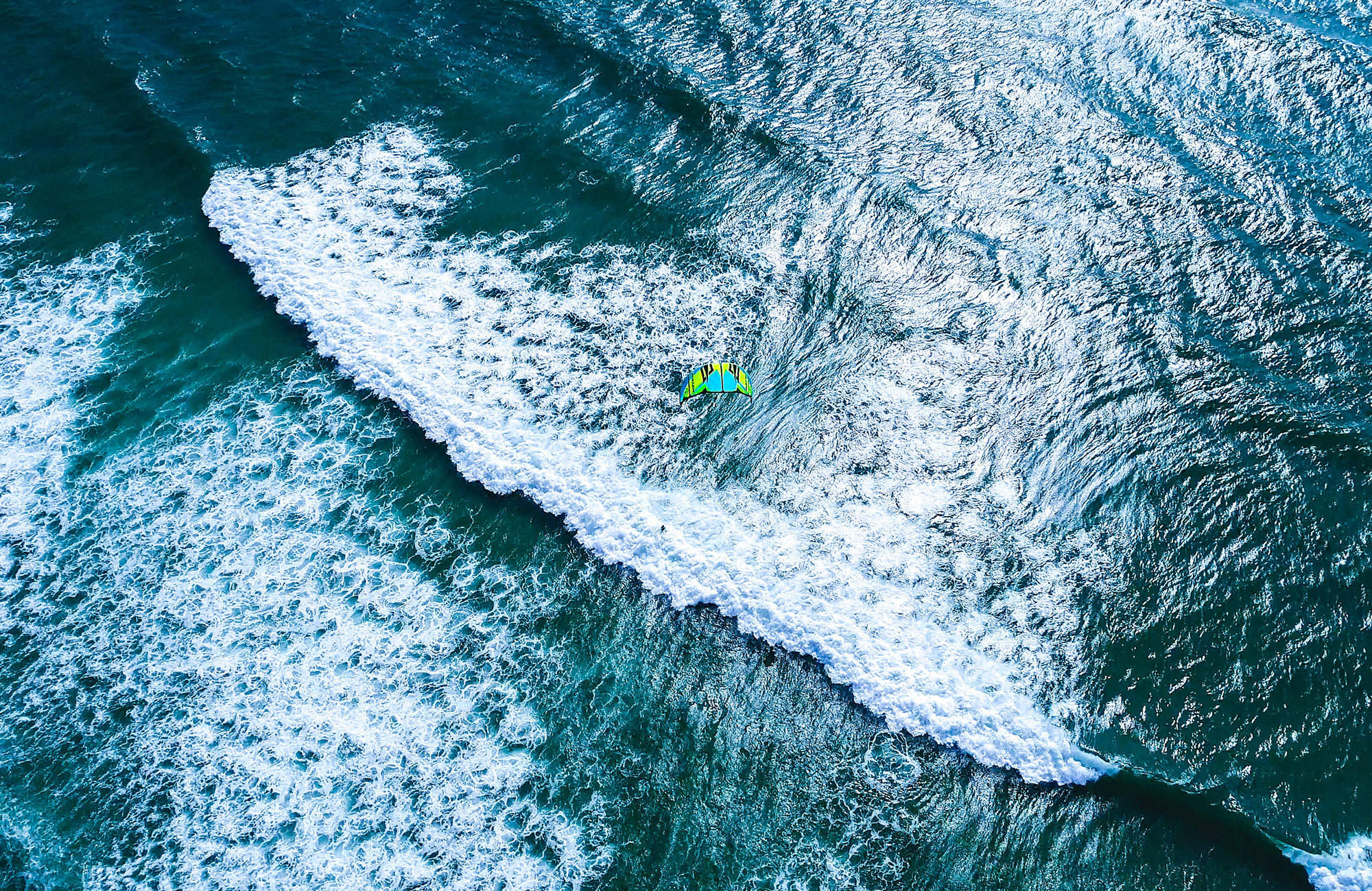Aerial view of a kitesurfer hitting a wave - KILROY