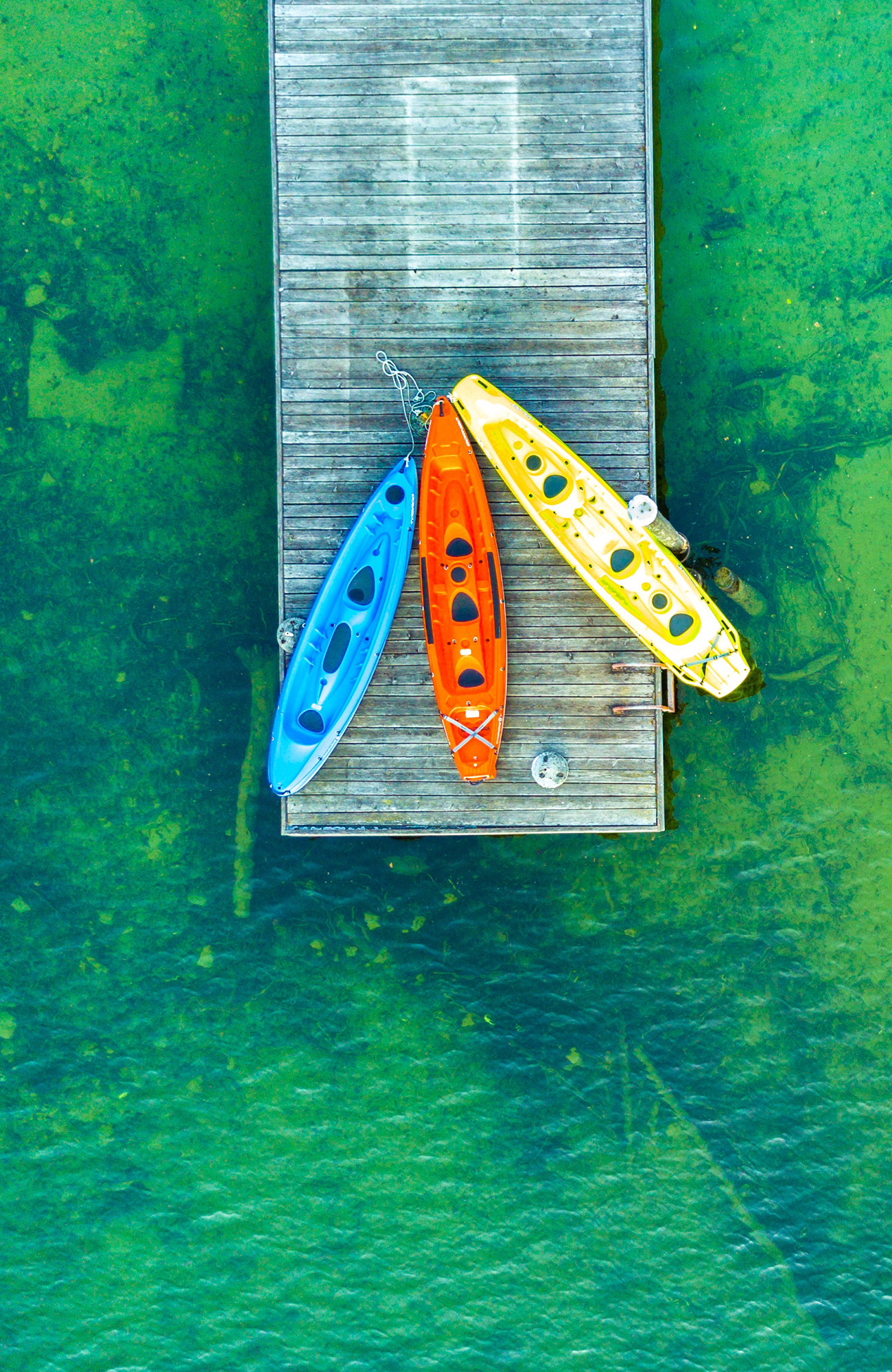 Aerial view of three kayaks on a wooden pier - KILROY