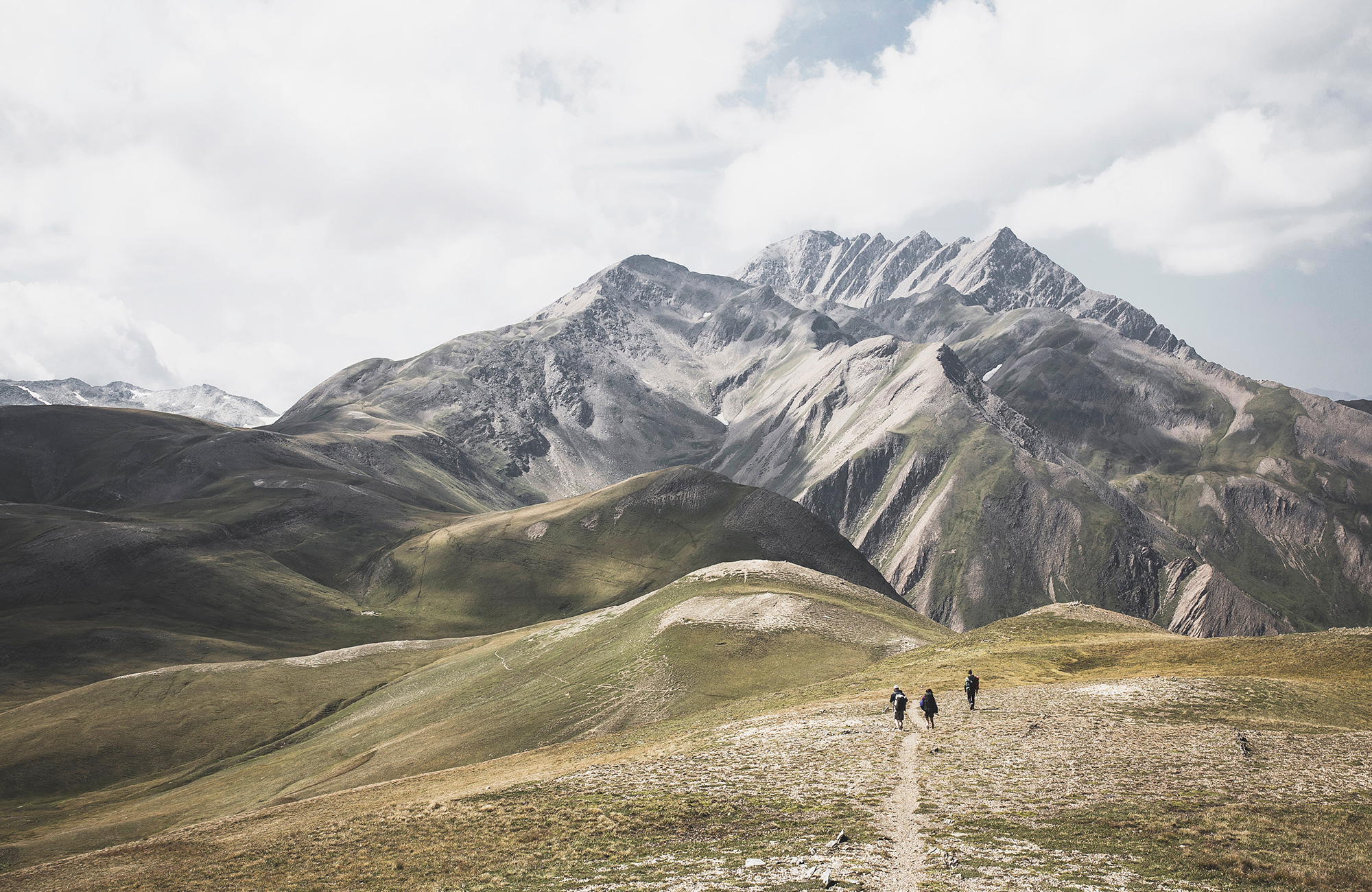 Image of a mountain range in Asia with people following a well-trodden walking route - KILROY