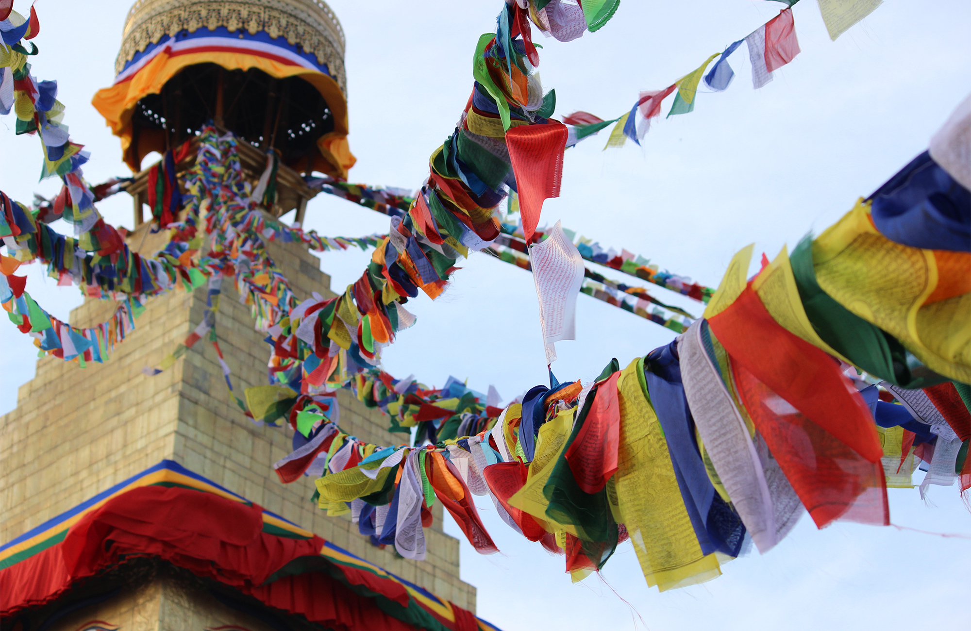 Image of a stupa in Nepal with colourful prayer flags - KILROY