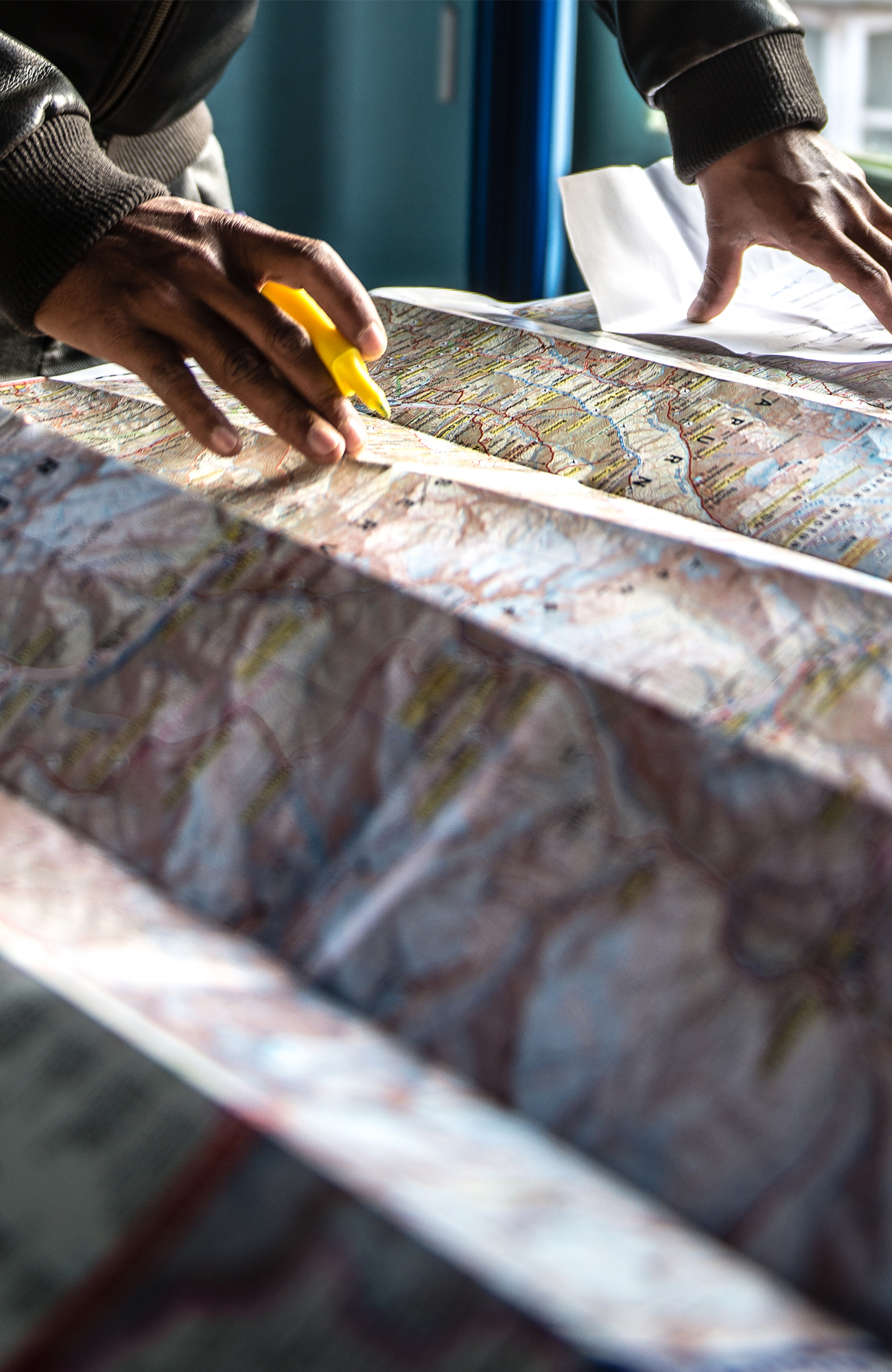 Image of a guide looking at a map of the Himalayas in Nepal - KILROY
