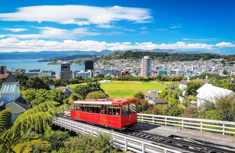 Image of a red tram with views across the city of Wellington on the North Island of New Zealand - KILROY
