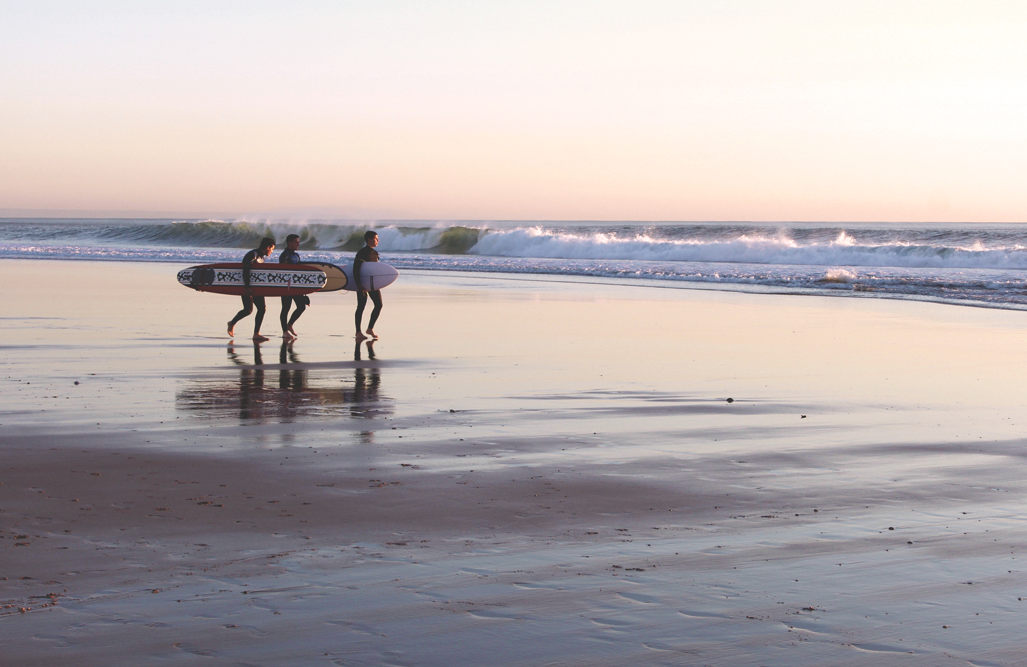 Image of surfers on a beach in Portugal - KILROY