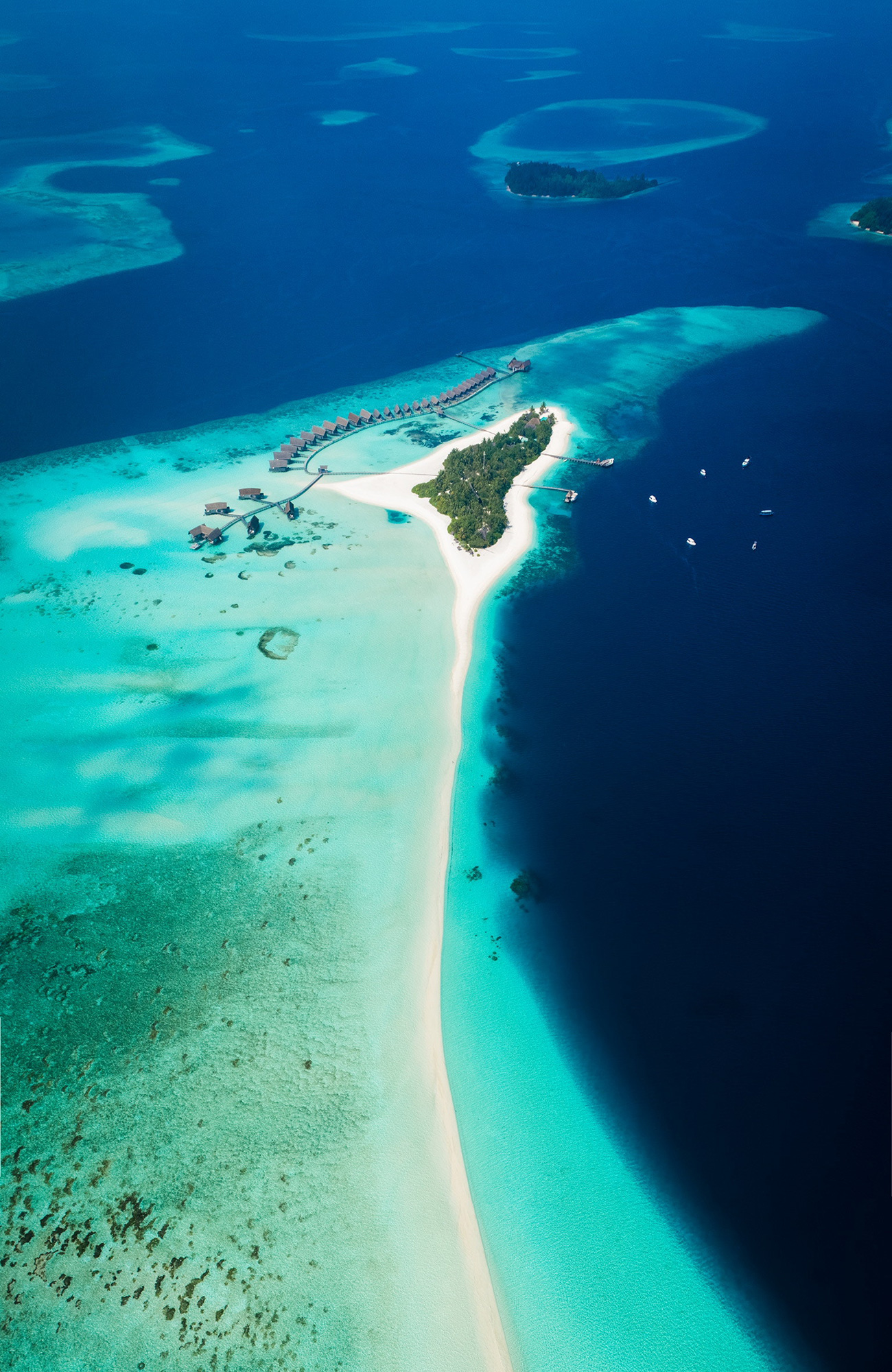 Aerial view of an island and its surrounding coral reefs in the Maldives - KILROY