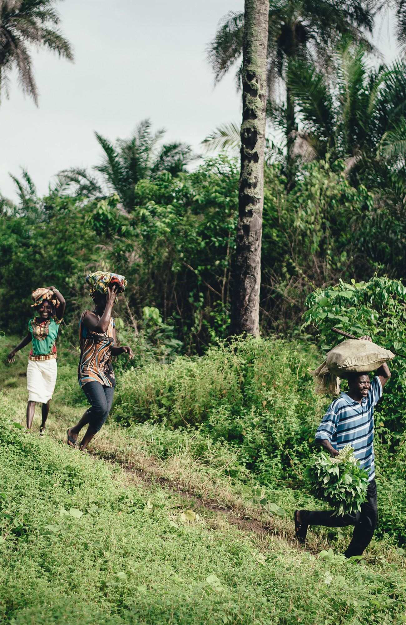 Image of people carrying sacks of goods on their head in Tanzania - KILROY