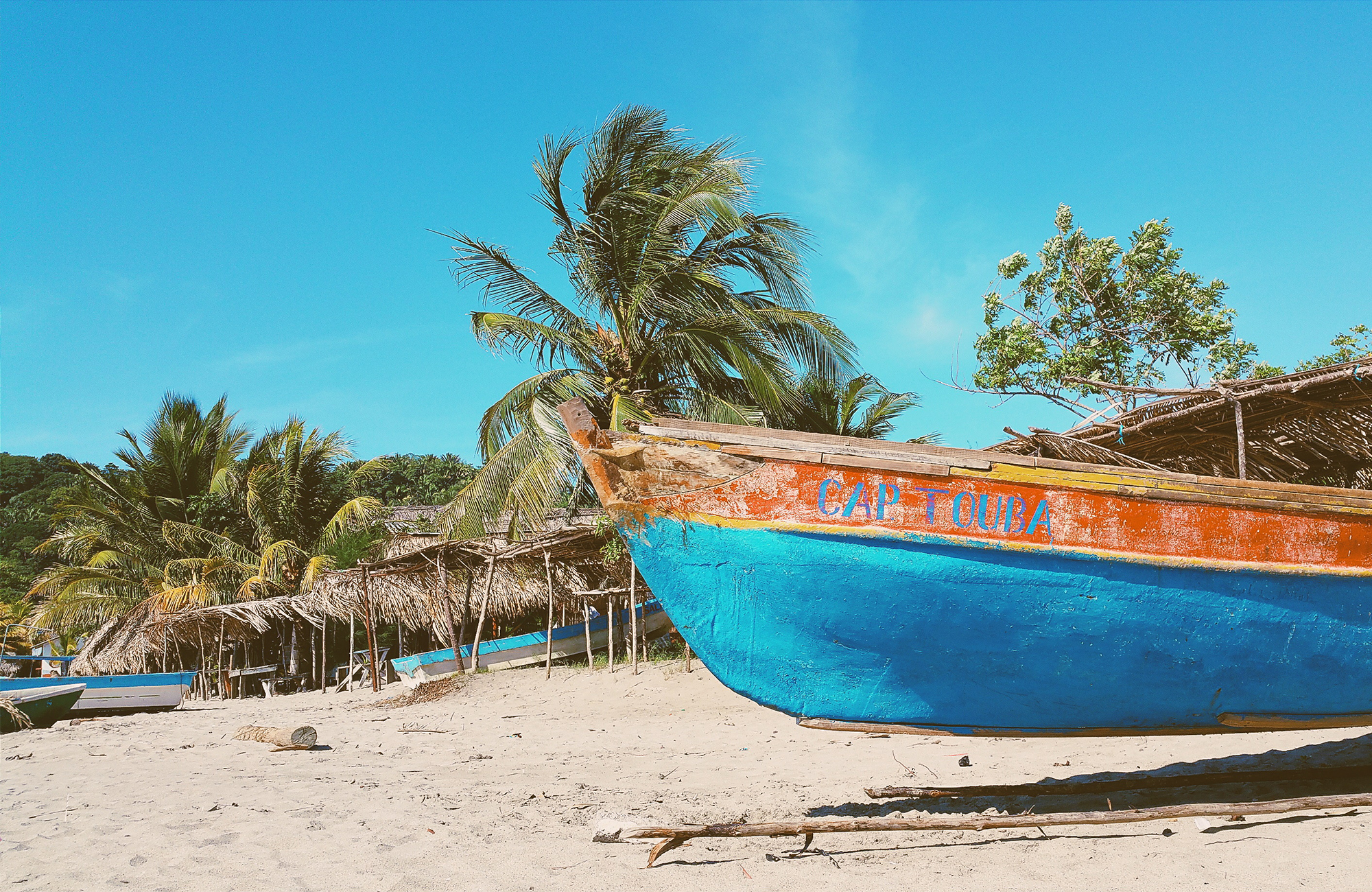 Image of a colourful boat on a beach in Honduras - KILROY