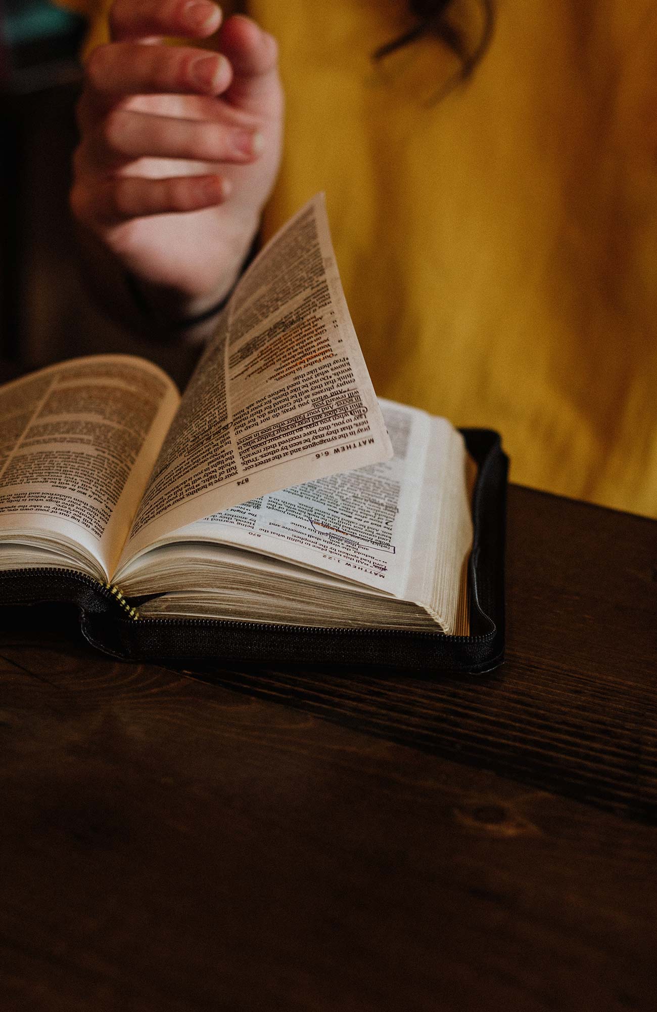 Close-up image of a woman flicking through a book - KILROY