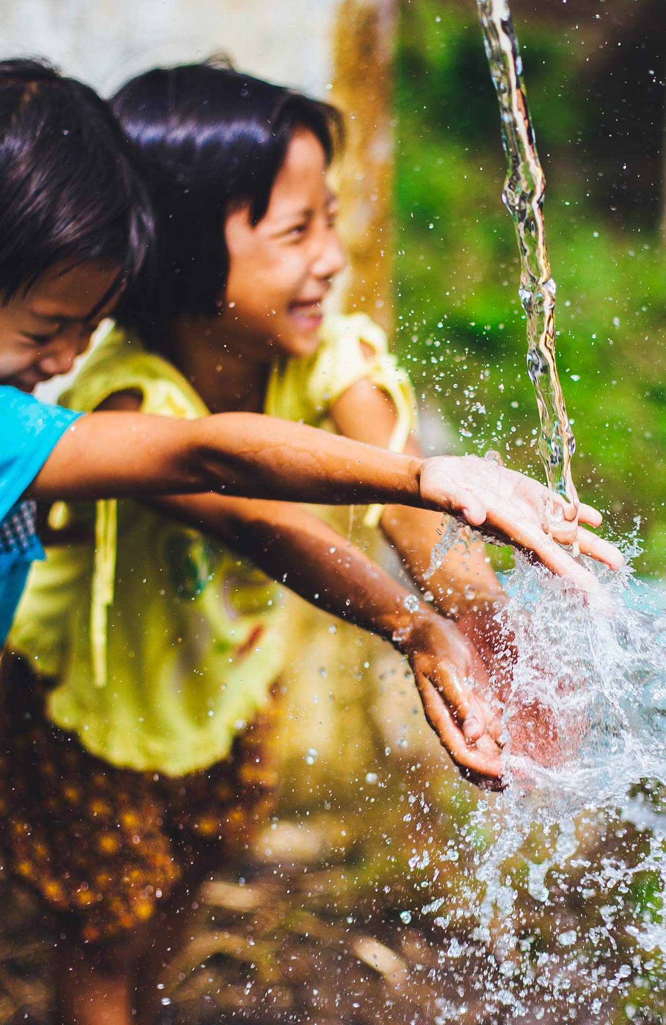 Image of young children playing with water in Thailand - KILROY