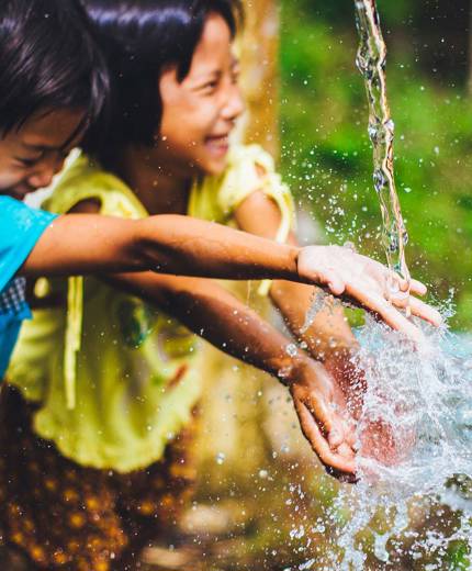 Image of young children playing with water in Thailand - KILROY