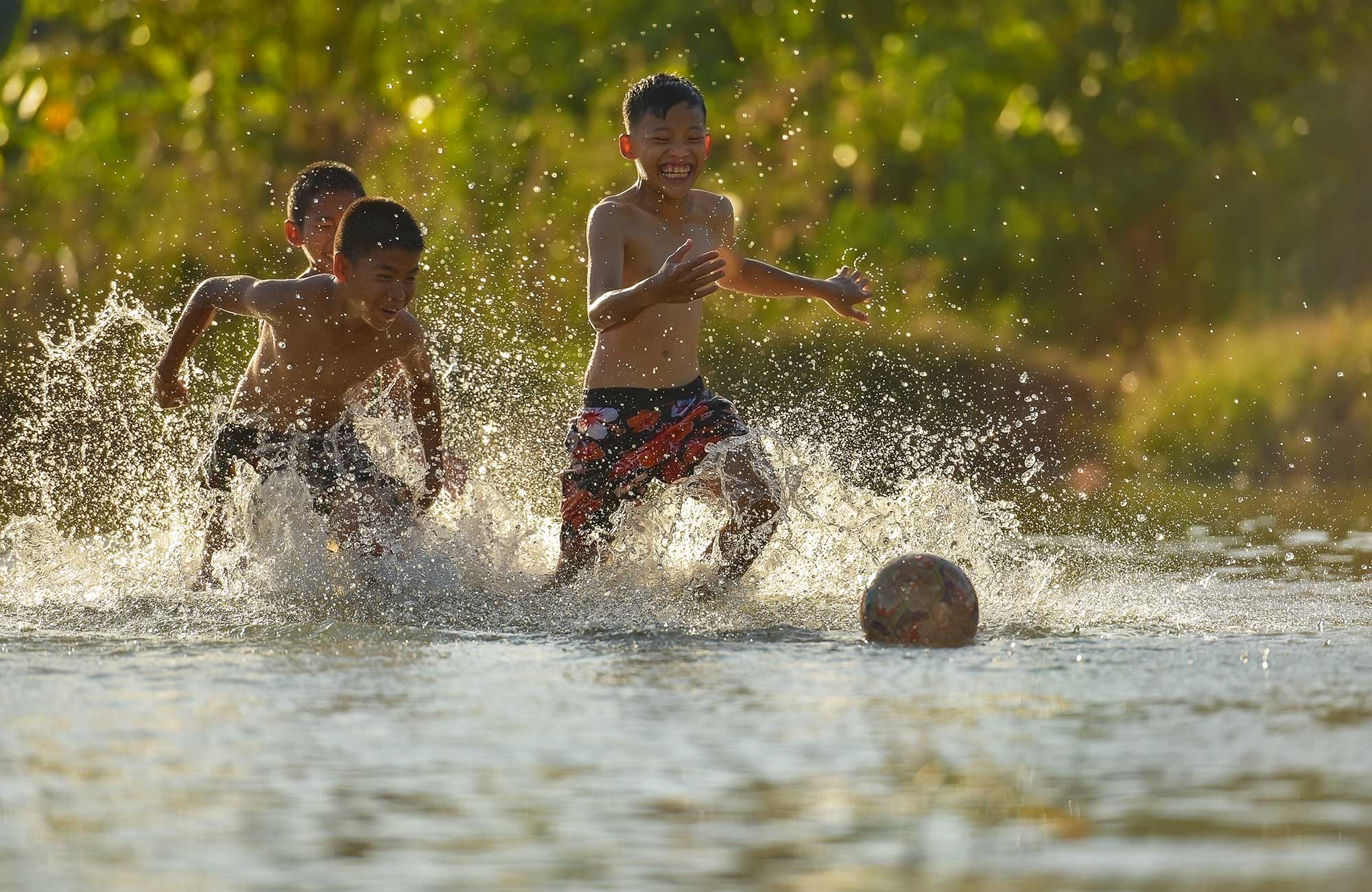 Image of young children chasing a football in Cambodia - KILROY