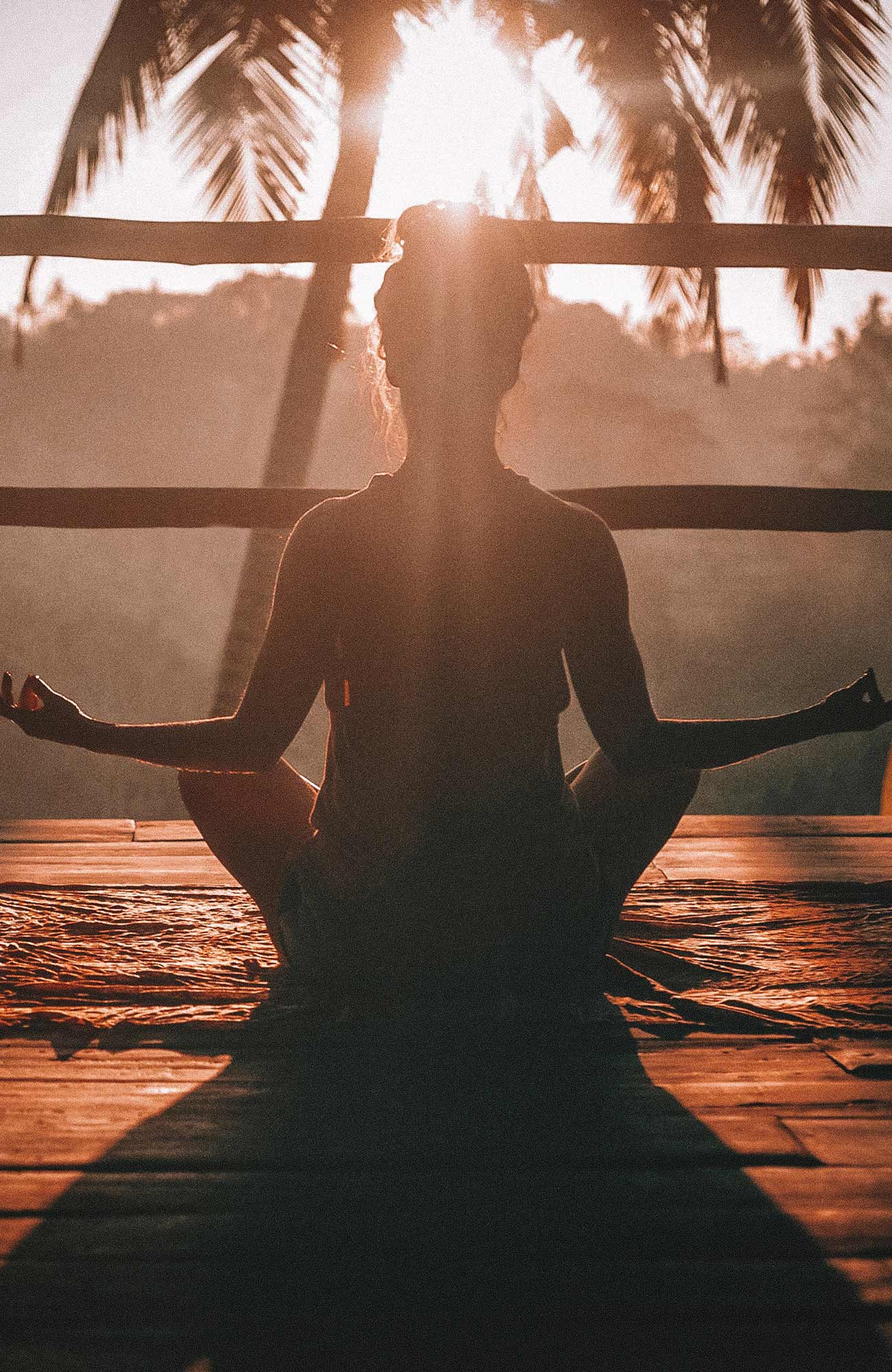 Image of a woman holding a yoga pose at sunset - KILROY