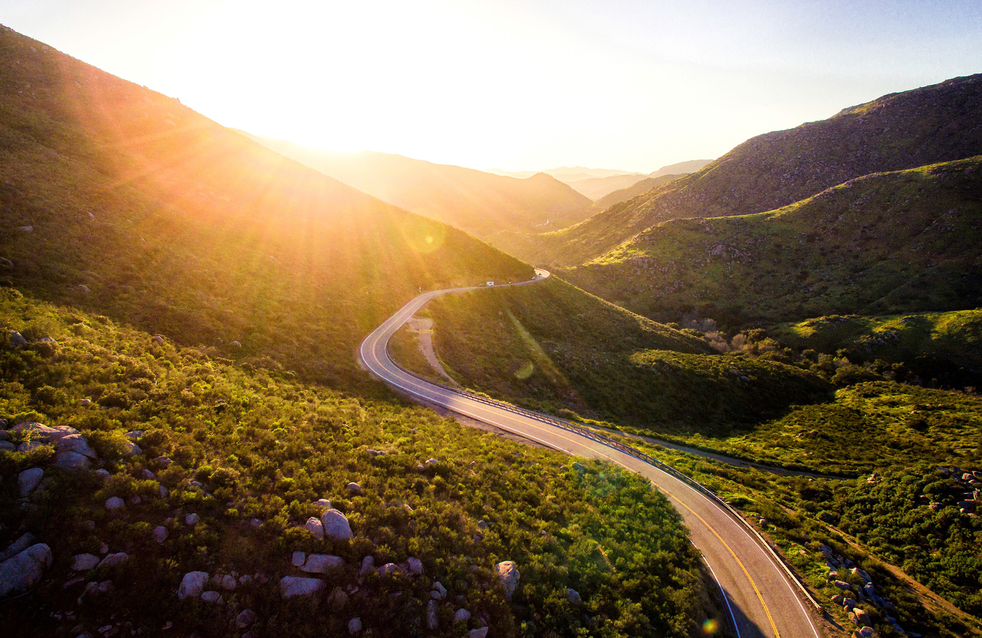 Image of a road in the States with the sun lighting the valley - KILROY