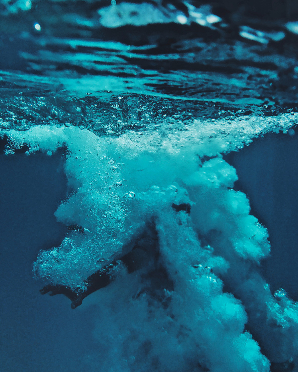 Image of a diver surrounded by bubbles under the water - KILROY
