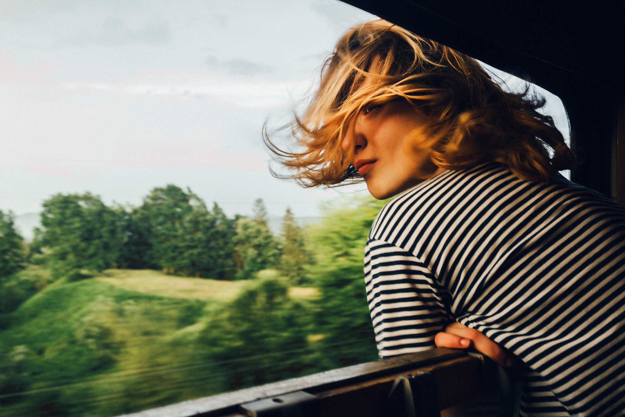 Girl looking out of the window of a moving train - KILROY UK