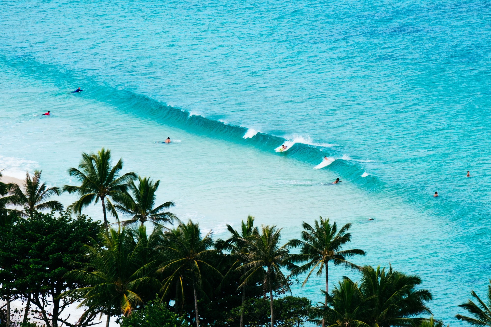 Image of surfers riding a breaking wave in Central America - KILROY