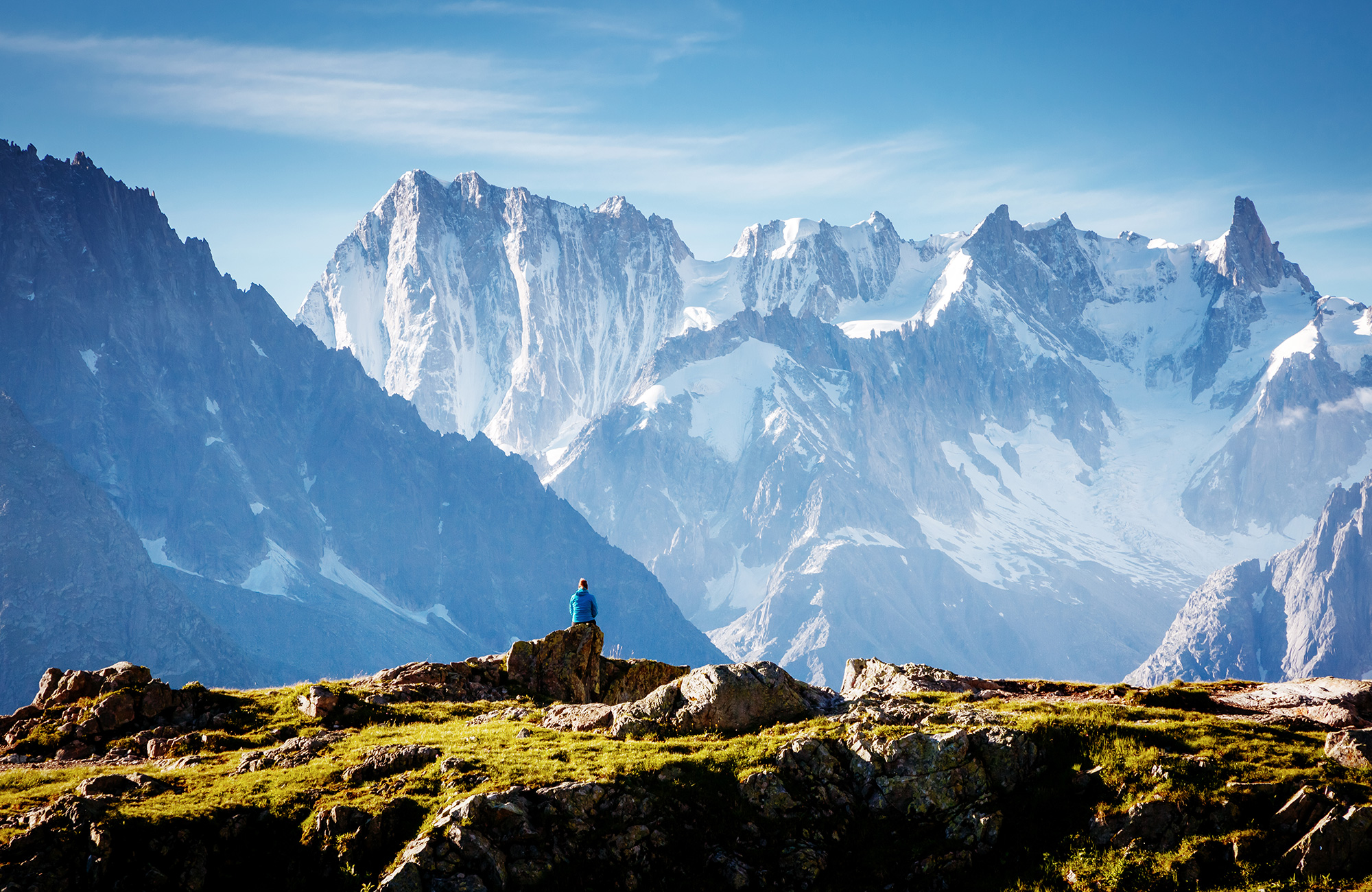 Image of a mountain range with a hiker in the foreground somewhere in Europe - KILROY