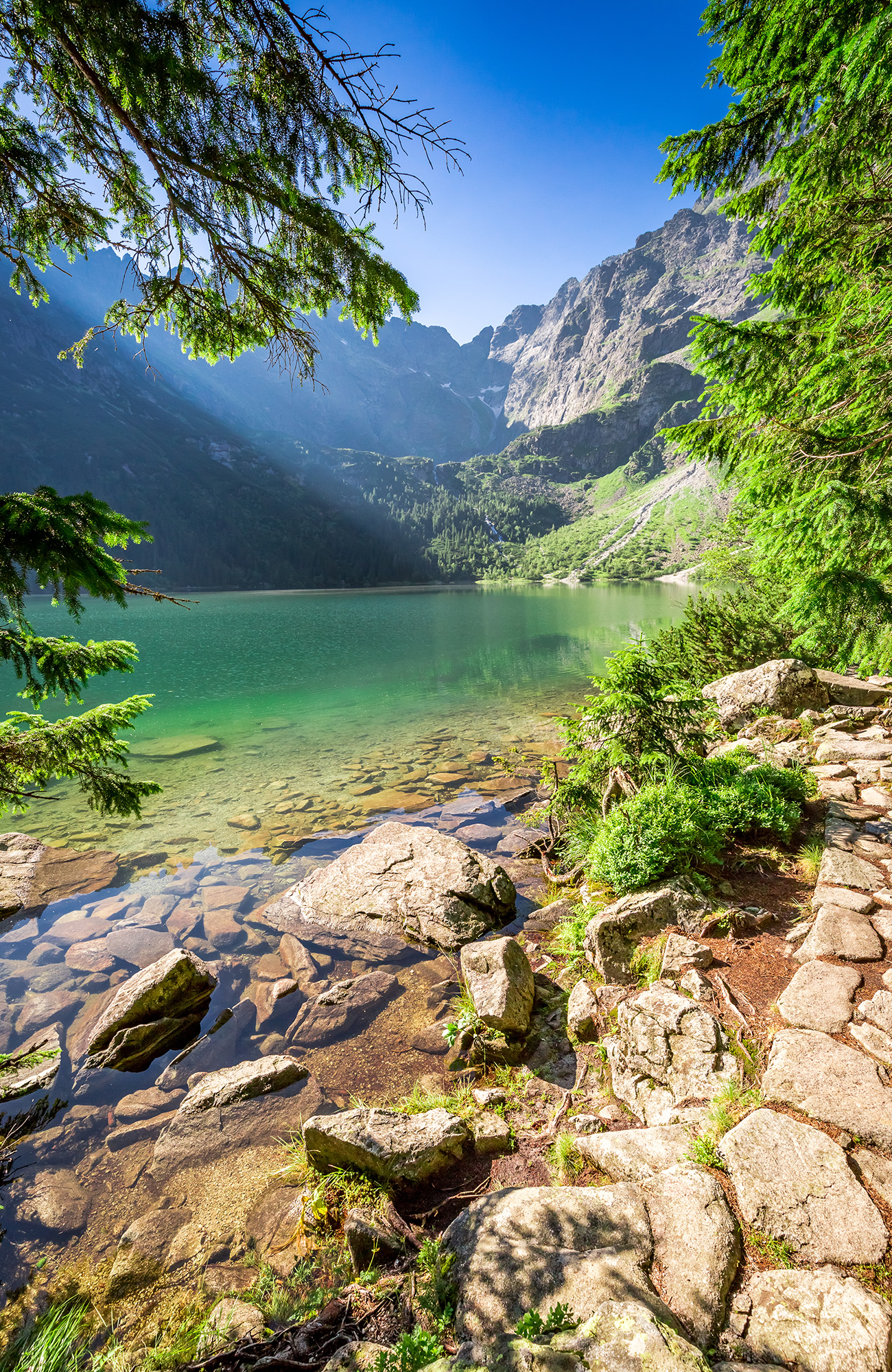 Image of a turquoise lake backed by mountains in Europe - KILROY