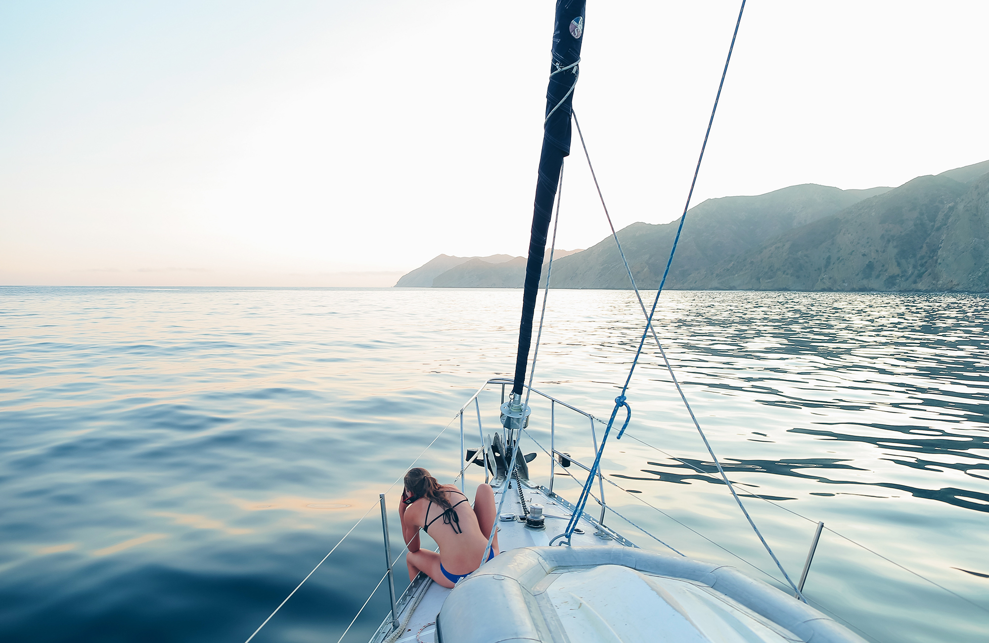 Image of a woman looking out to sea from a sailing boat - KILROY