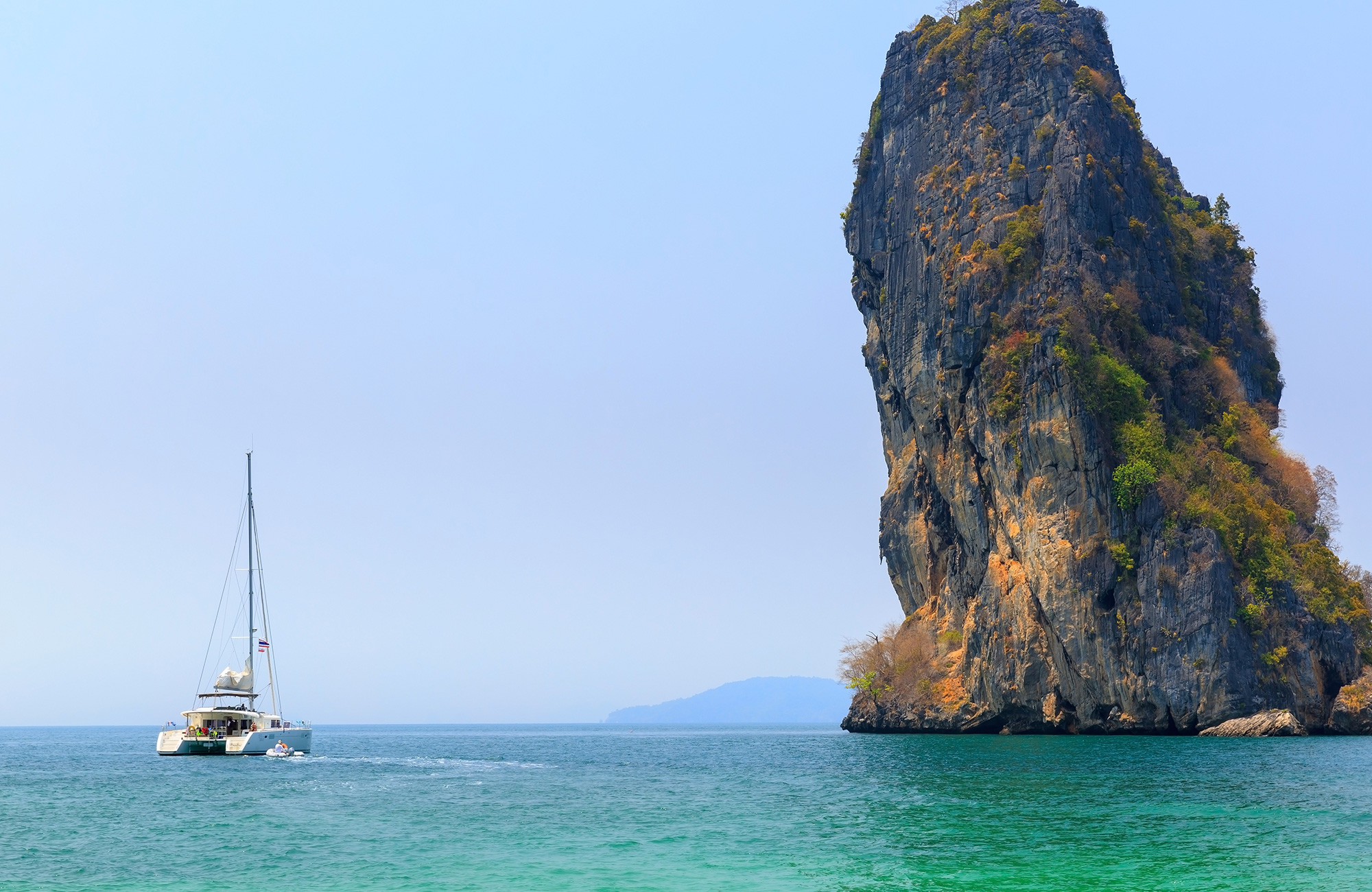 Image of a catamaran boat near a karst island in Thailand - KILROY