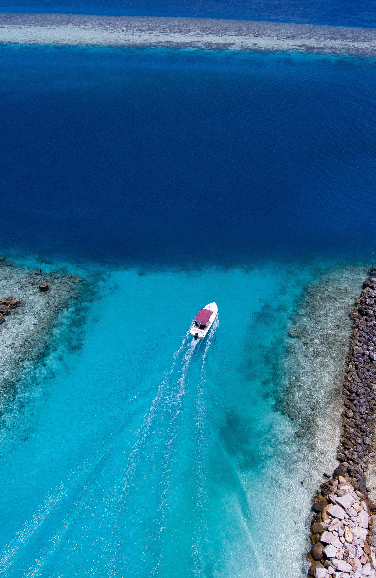 Image of a boat cruising across brilliant blue waters - KILROY