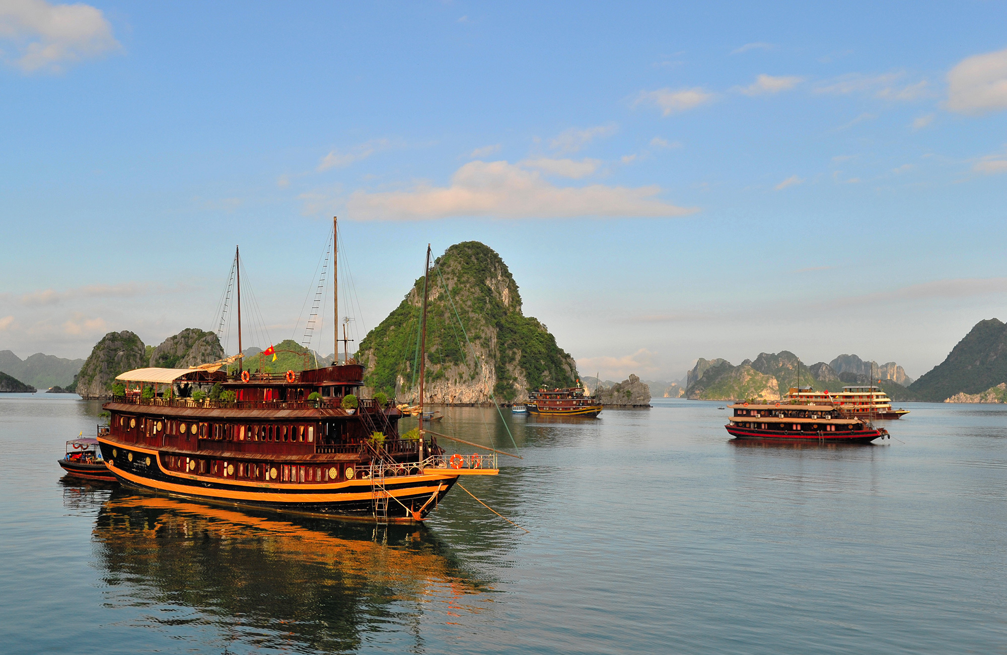 Image of traditional junk boats cruising in Halong Bay - KILROY