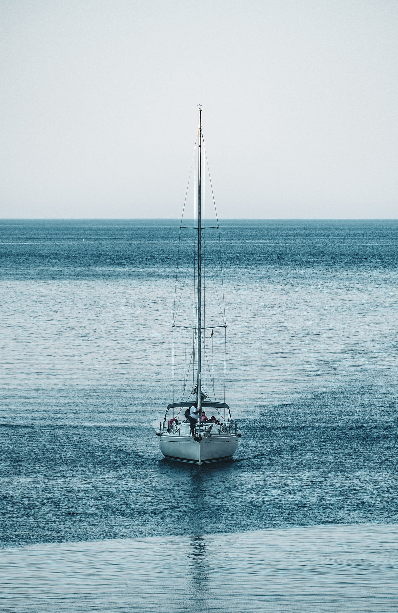 Image of a sail boat sailing across calm waters - KILROY