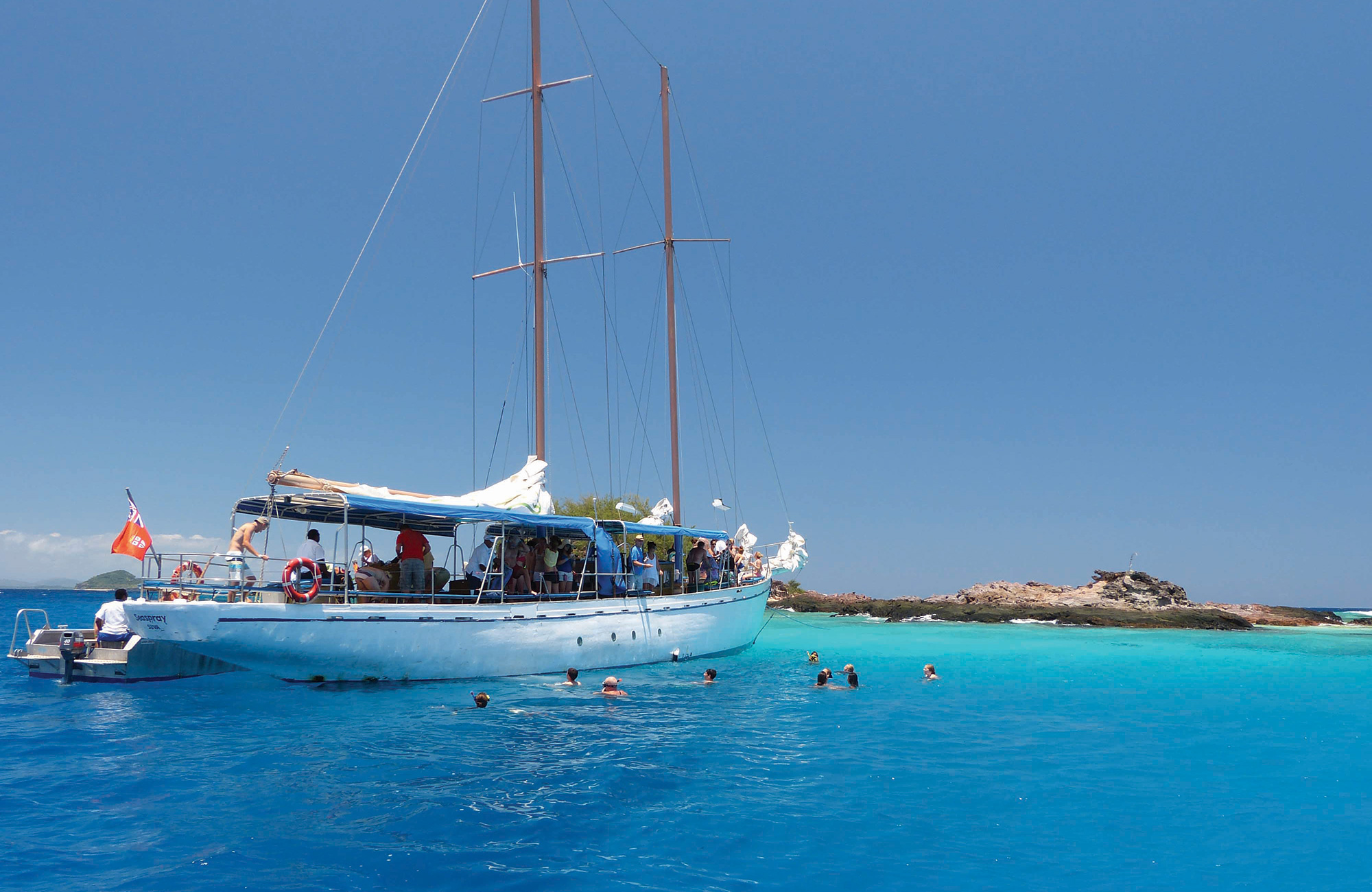 Image of a sail boat anchored in brilliant blue waters in Fiji - KILROY
