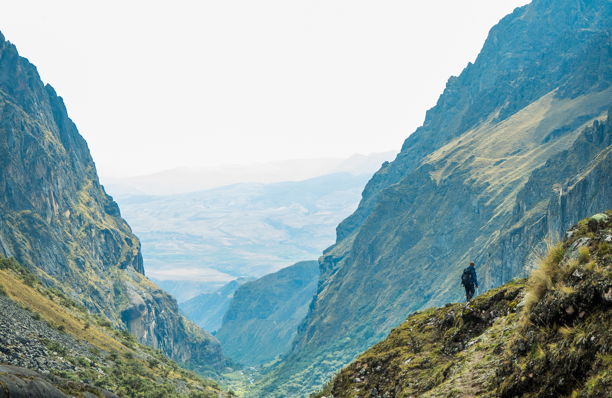 Image of a hiker walking a route along a mountain pass somewhere in South America - KILROY