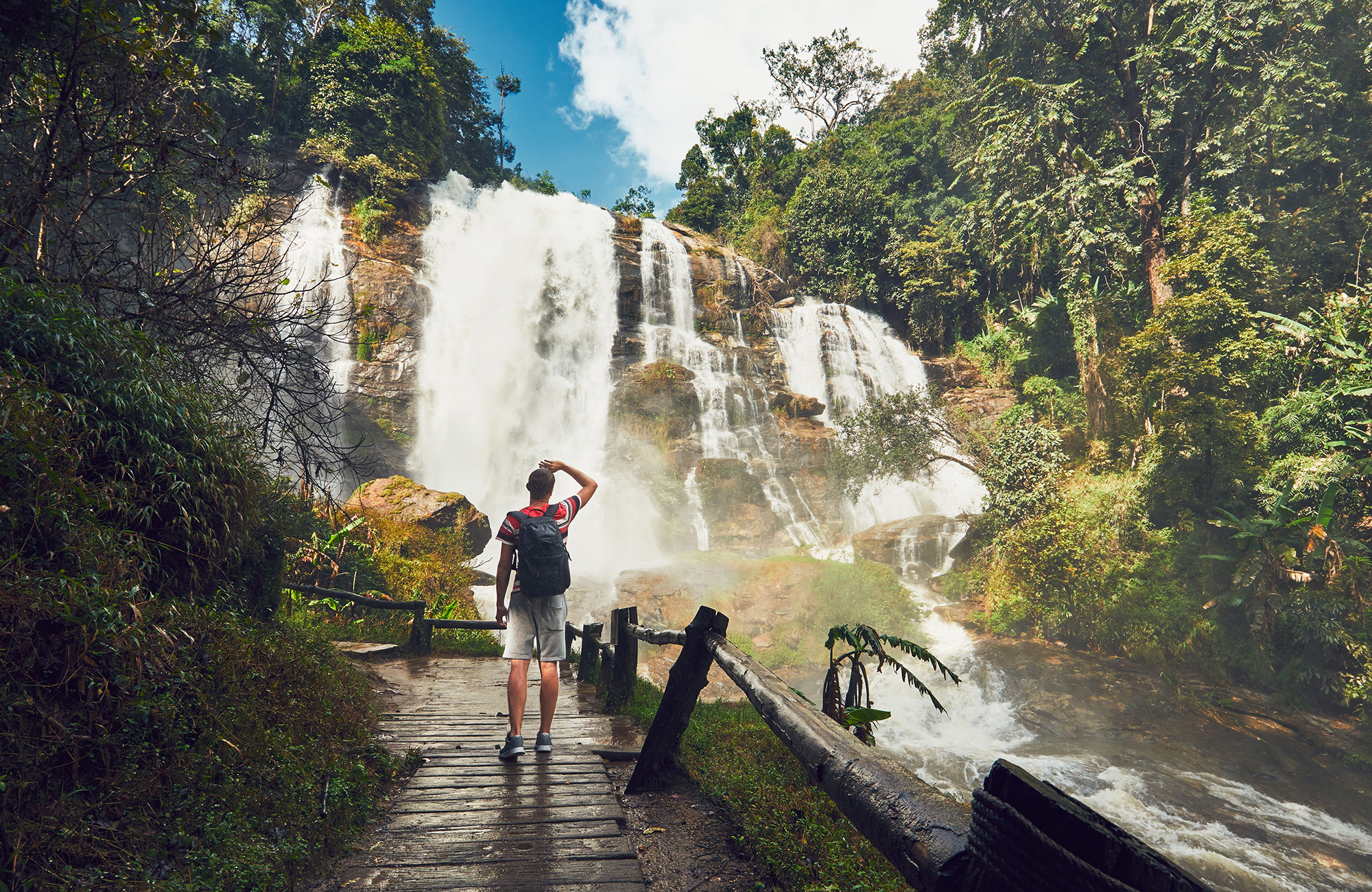 Image of a traveller looking at a waterfall on a trek in Thailand - KILROY