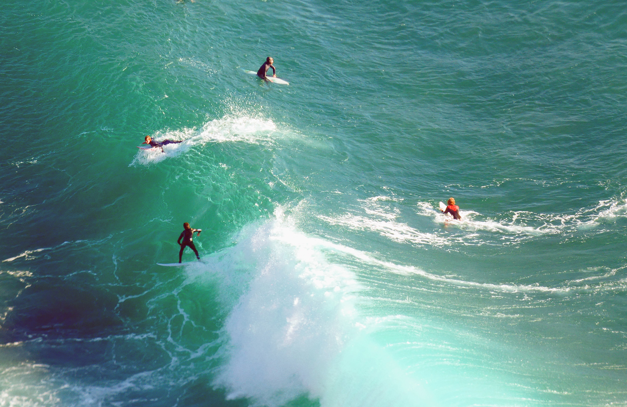 Image of surfers on the green coloured waves of the Atlantic coast in Portugal - KILROY