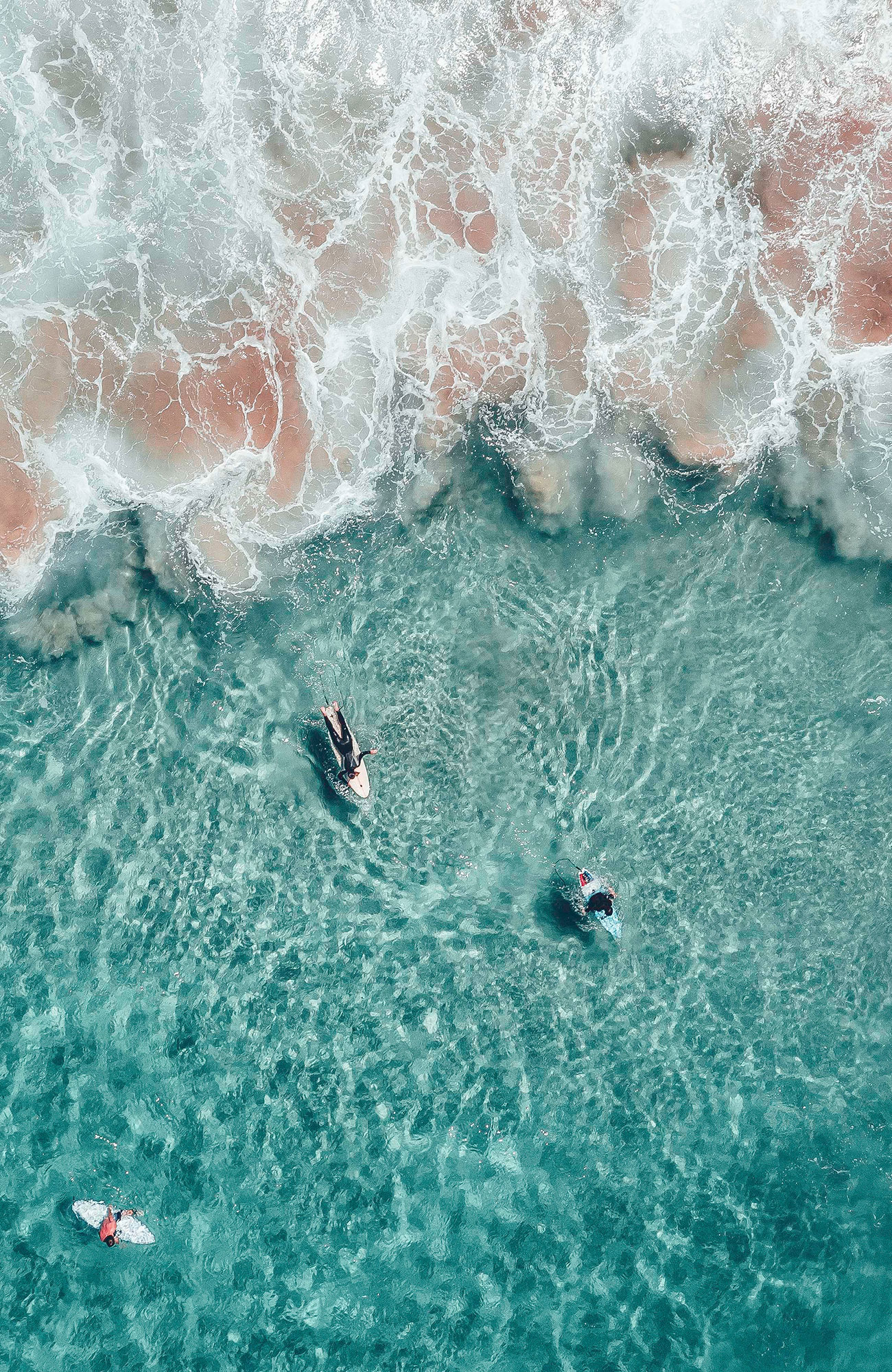 Aerial view of surfers in crystal clear waters in the USA - KILROY