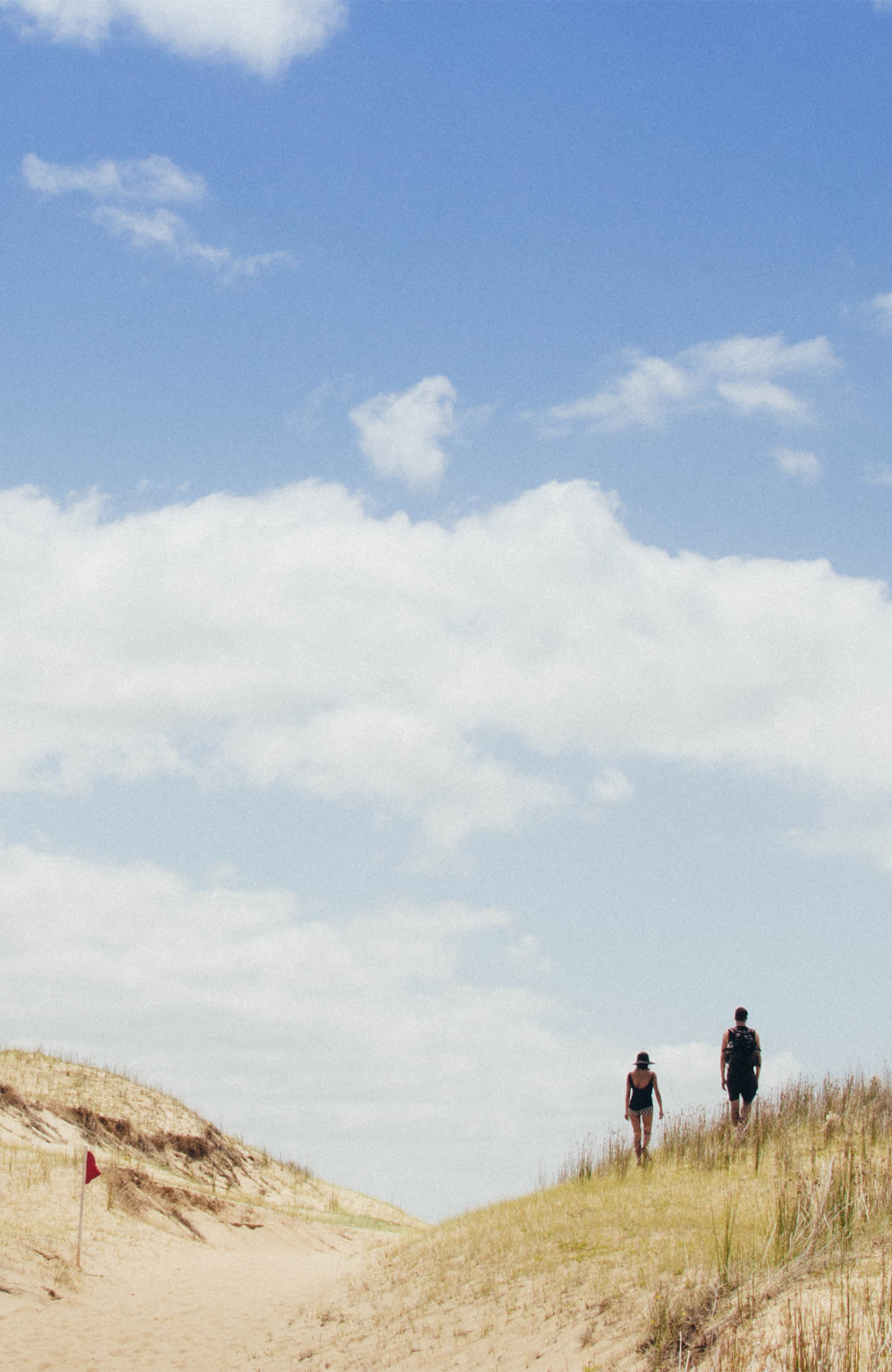 Image of people walking along a beach in Uruguay - KILROY