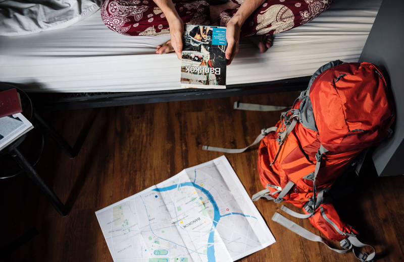 Travel planning with a travel guide, a map and a backpack