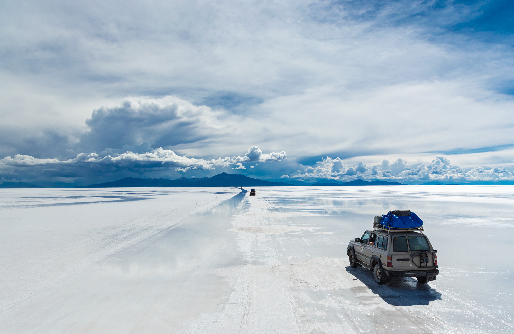 4x4 vehicle on rain-spattered salt flats in Bolivia - KILROY