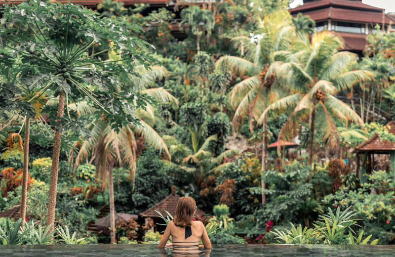 Image of a woman in an infinity pool facing the jungle in Bali - KILROY