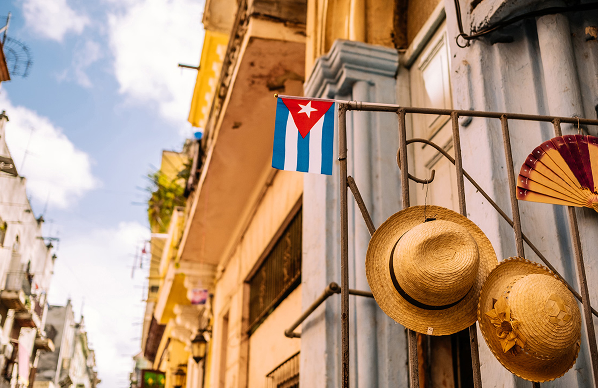 Image of hats hanging on a door with the Cuban flag - KILROY