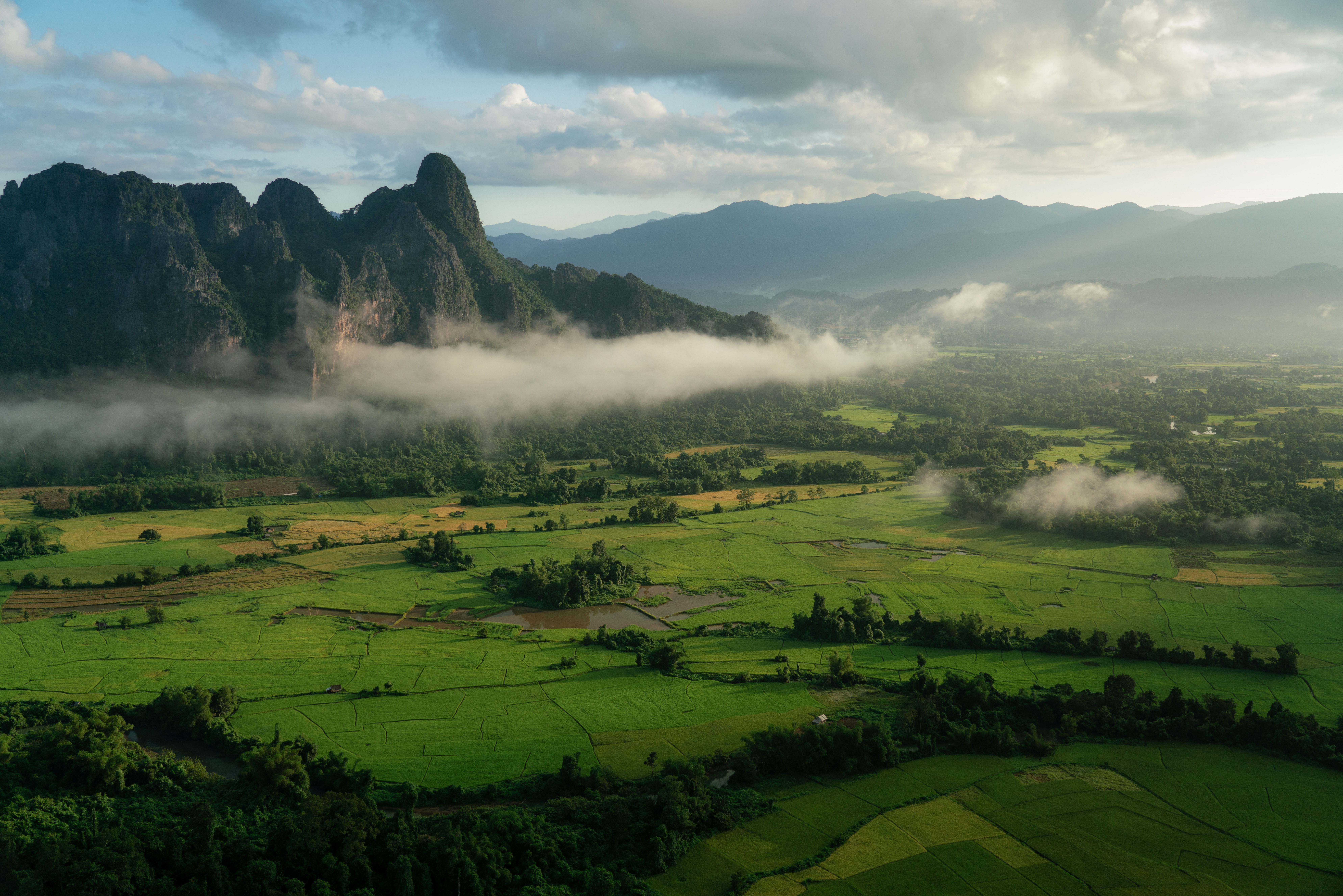 Image of a lush green valley in Vang Vieng, Laos - KILROY