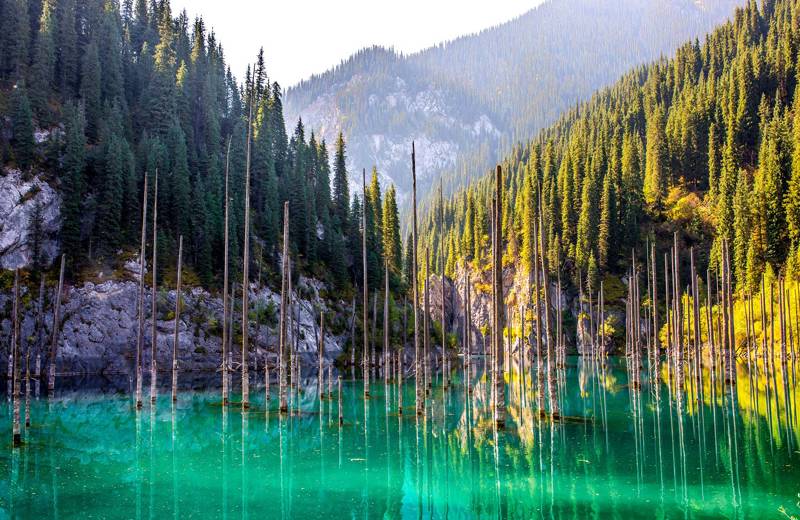 Image of an emerald lake surrounded by forests and mountains in Kazakhstan - KILROY
