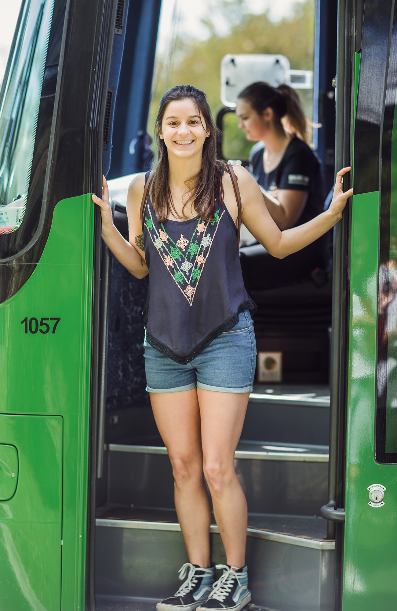 A happy traveller on a Kiwi Experience bus in New Zealand - KILROY