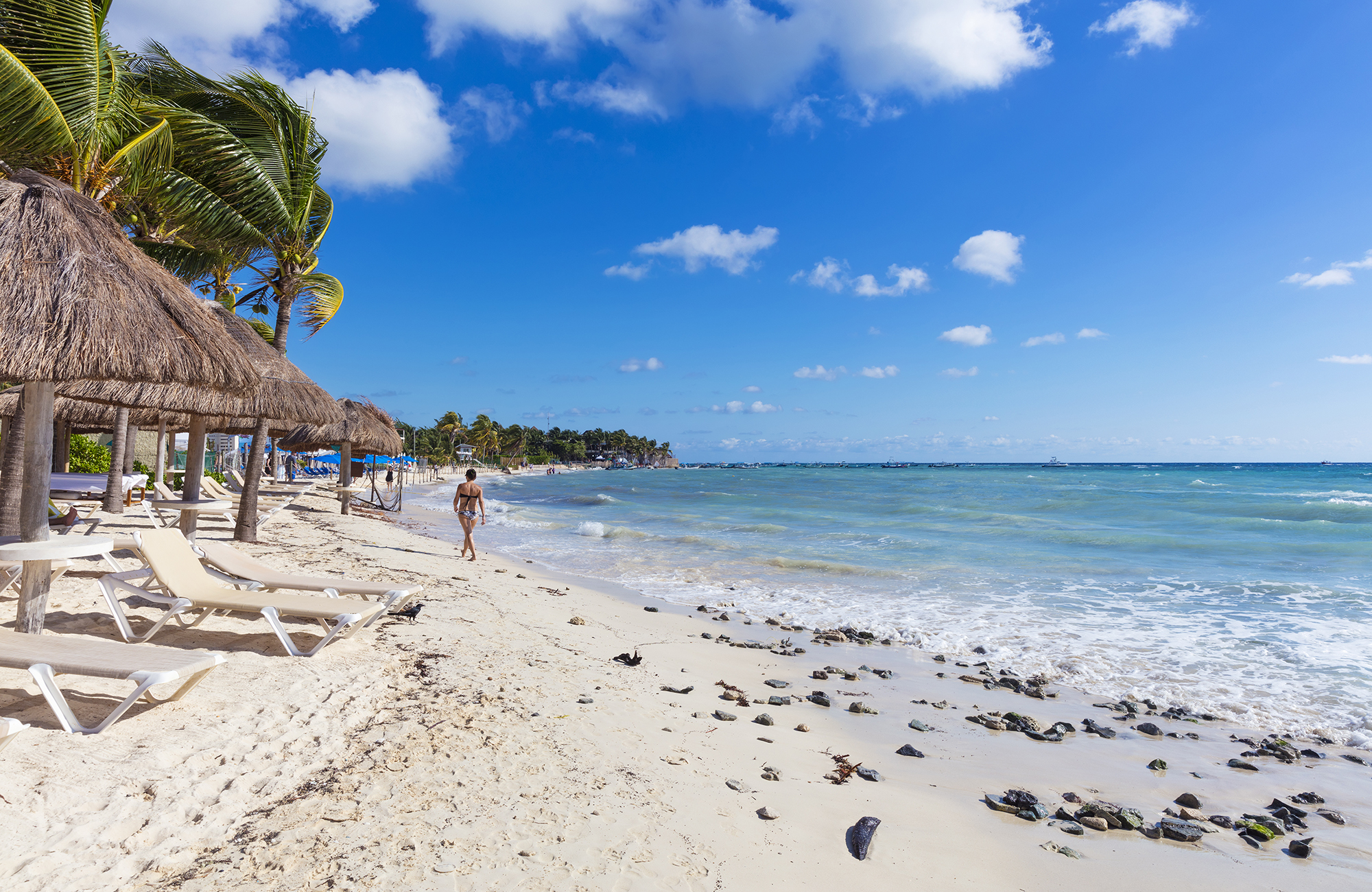 Woman walking along a aplm-fringed beach in Playa del Carmen in Mexico - KILROY