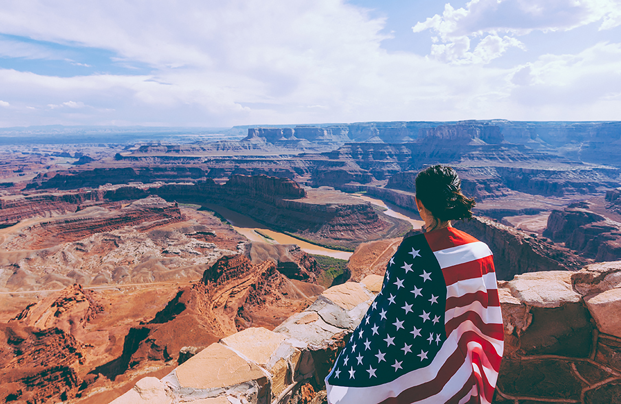Image of a young female wearing an American flag around her shoulders - KILROY