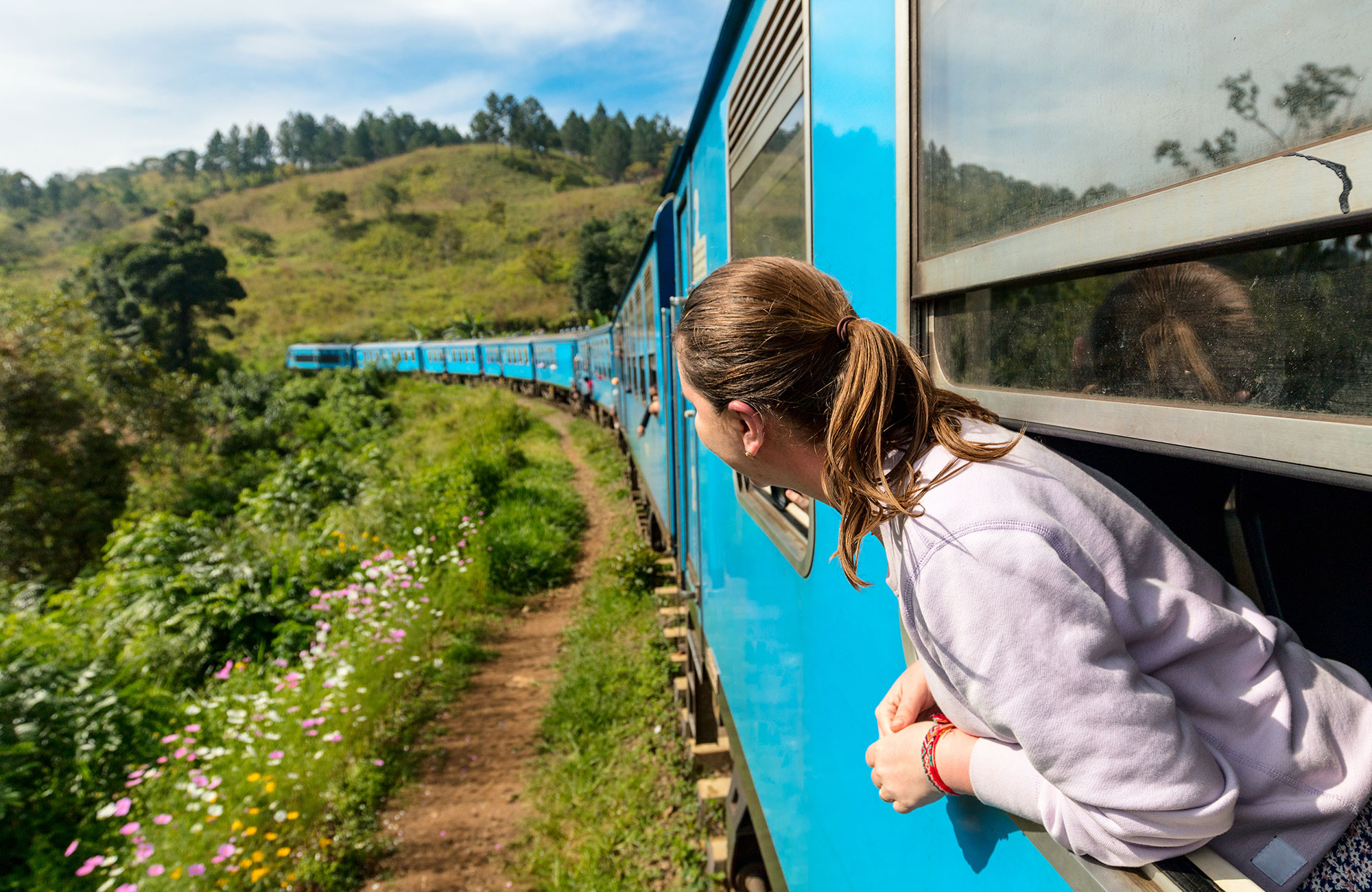 Image of a young woman looking out of a train in Asia - KILROY