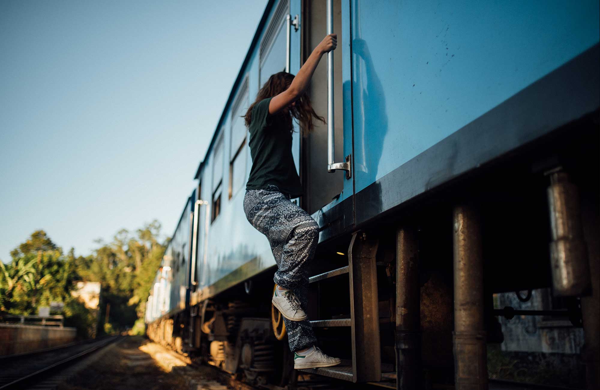 Image of a young female traveller boarding a train - KILROY