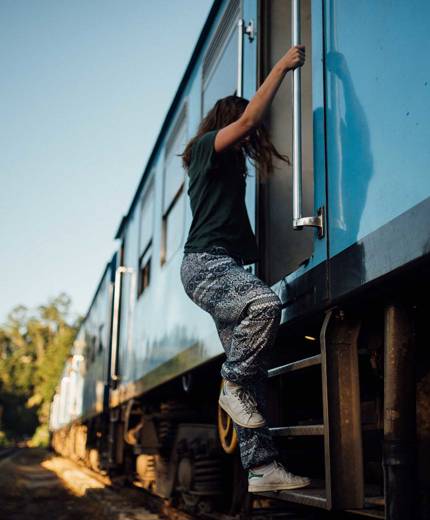 Image of a young female traveller boarding a train - KILROY