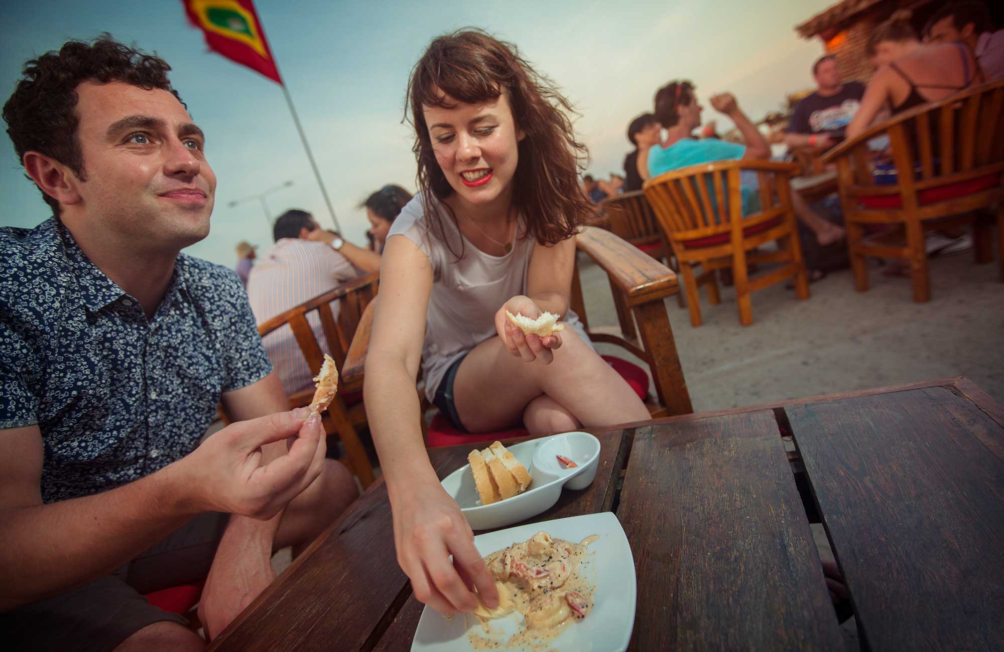 Image of a couple eating on a beach in Colombia - KILROY