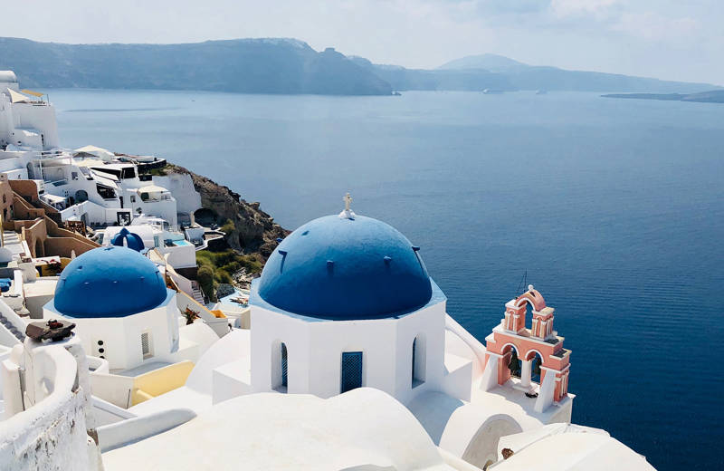 Image of the iconic blue-domed churches of Santorini in Greece - KILROY