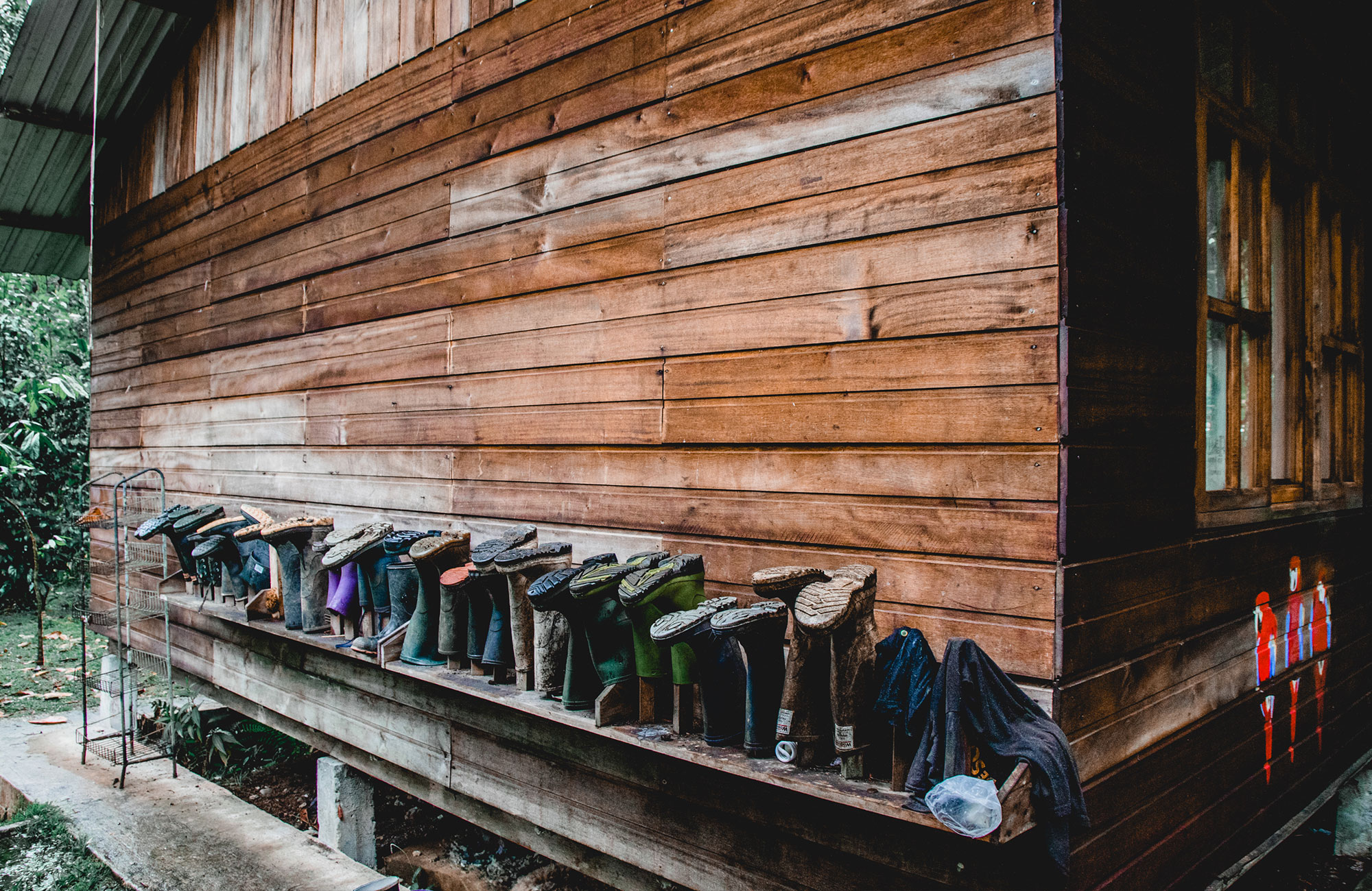 Image of a row of boots outside a hut on a volunteer project in South America - KILROY