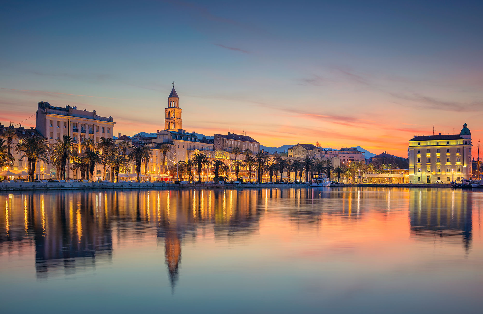 Image of Split harbour lit up at dusk in Croatia - KILROY