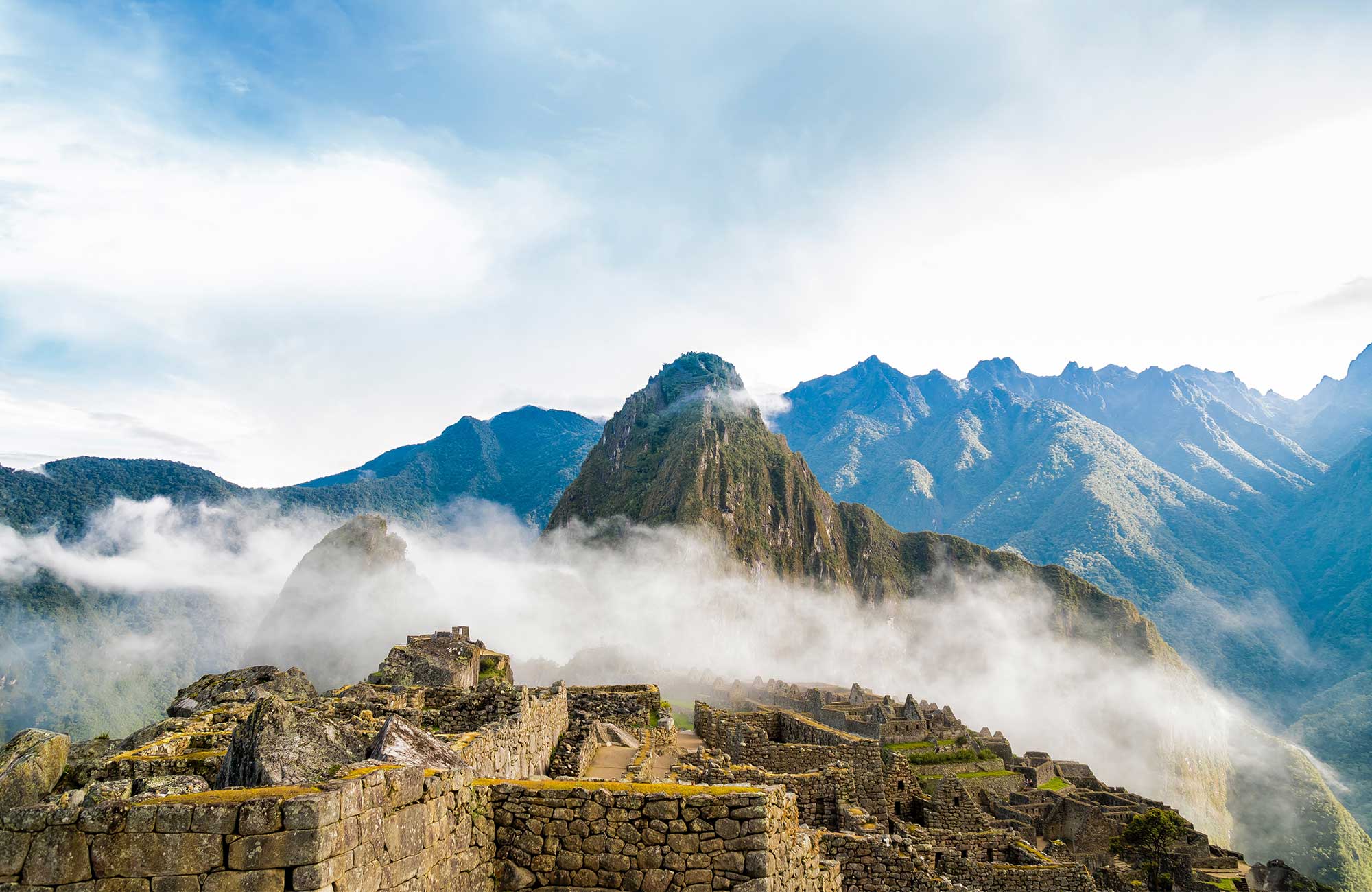 Image of Inca ruins backed by mountains at Machu Picchu in Peru - KILROY